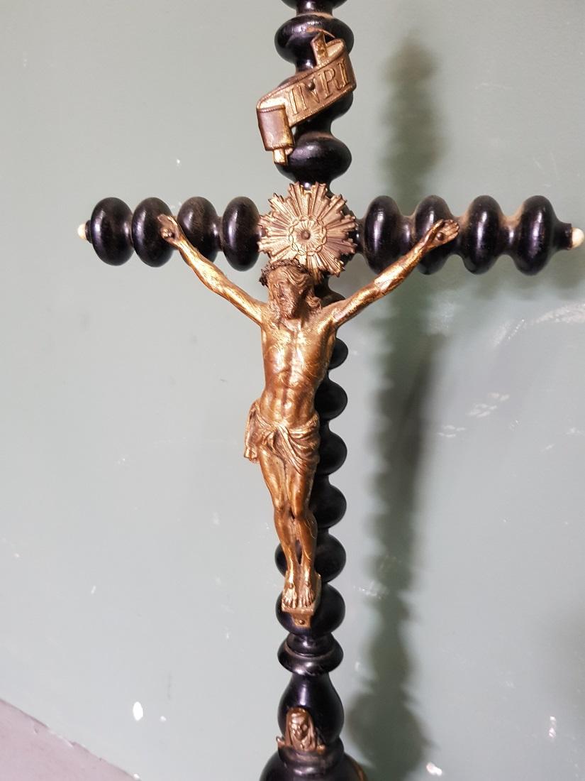 Antique blackened wooden cross with bronze Christ and various brass ornament all around, in a good but weathered condition due to age. Originating from the 19th century.

The measurements are,
Depth 12 cm/ 4.7 inch.
Width 21 cm/ 8.2