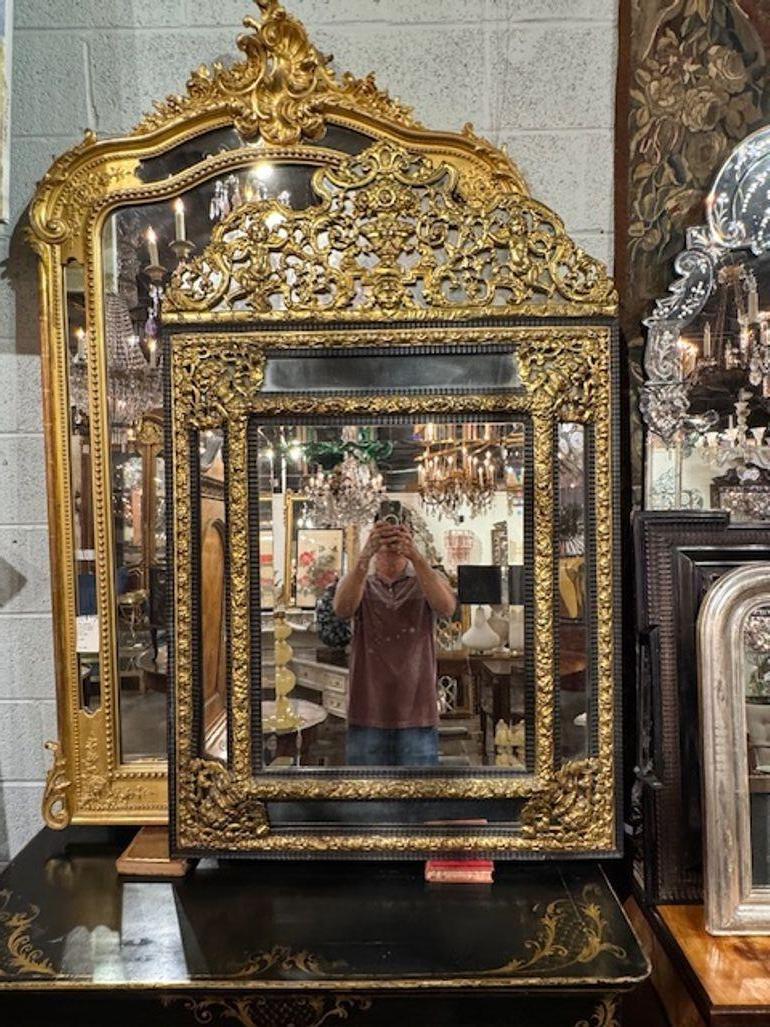 Elégant miroir à coussin en ébène et laiton repoussé du 19ème siècle. Très beau motif complexe et orné. Une belle déclaration ! Circa 1850.
35w x 55h