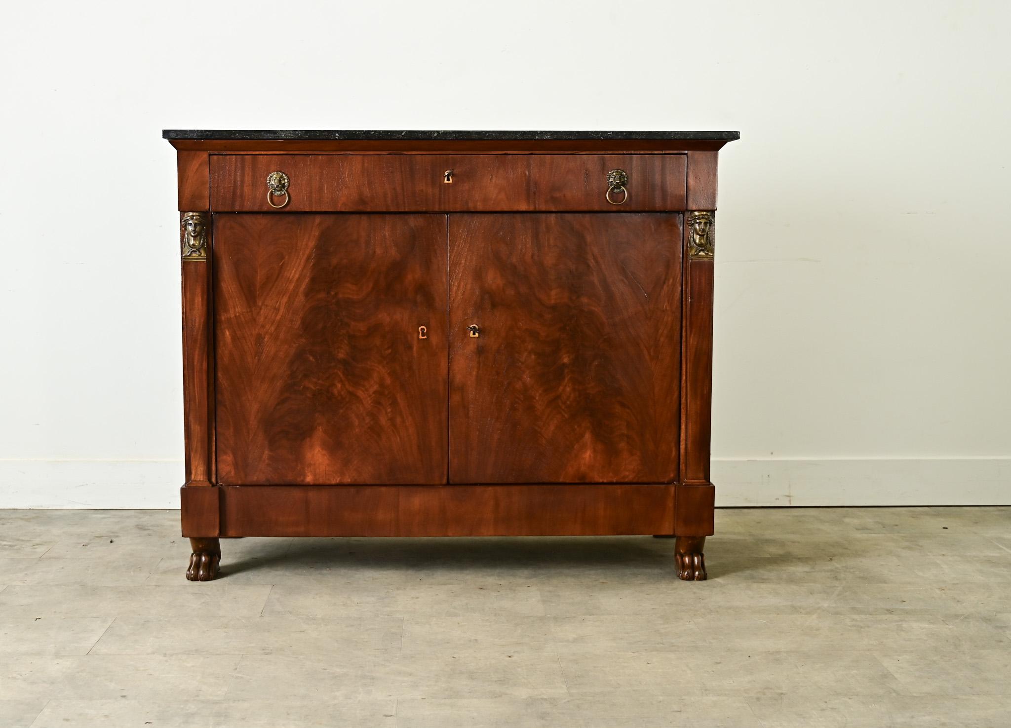 Un buffet mozzafiato in stile Impero Francese, di produzione olandese, in mogano fiammato con piano in marmo scuro coordinato per un look classico e neoclassico. La lastra presenta costellazioni di luce che si marmorizzano sulla pietra nera, come