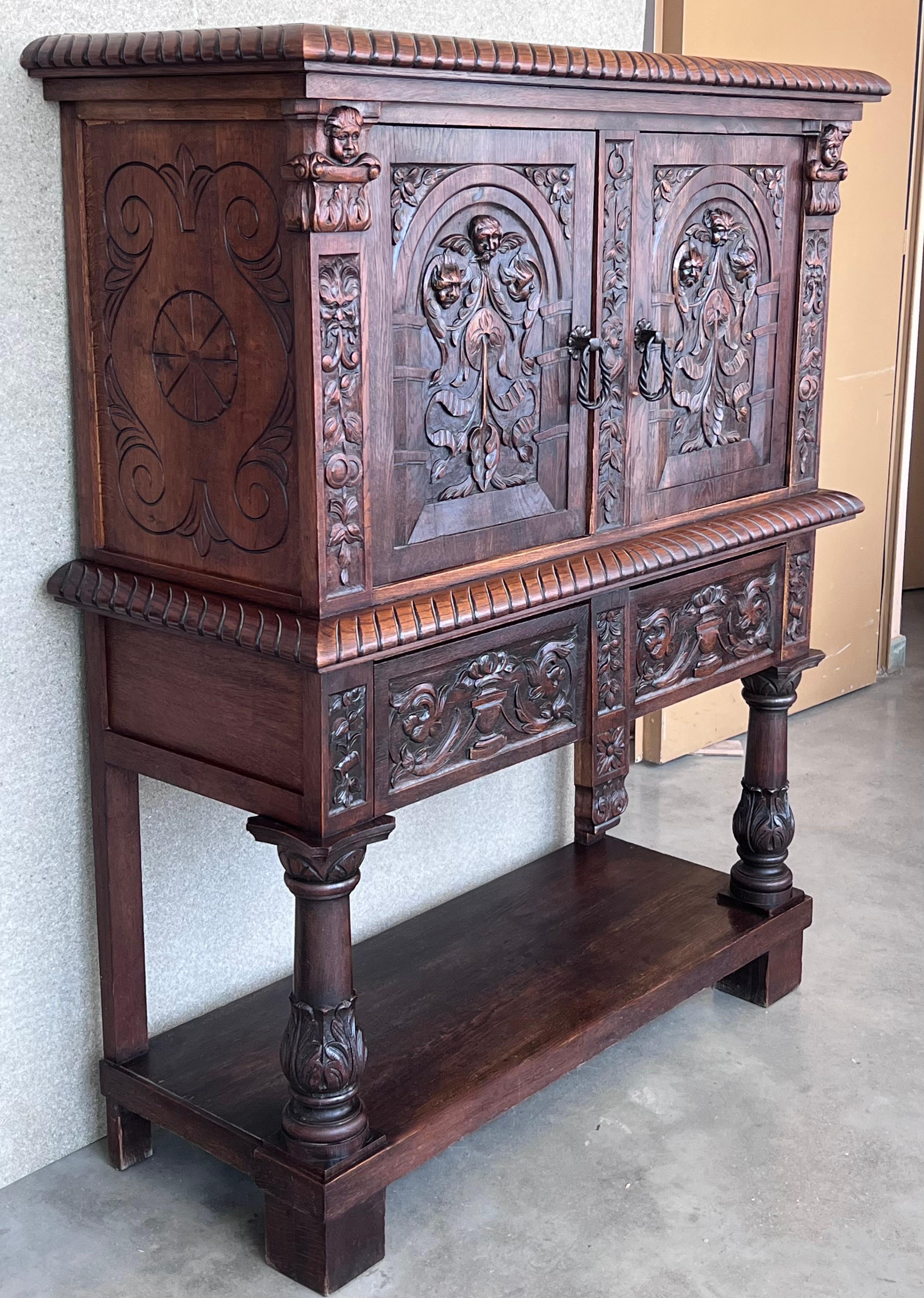 20th century Spanish hand carved Renaissance raised cabinet was rendered from dense, old-growth quarter sawn walnut, examples of which are on display in museums across Belgium and Holland that are over 1,000 years old! This stunning example features