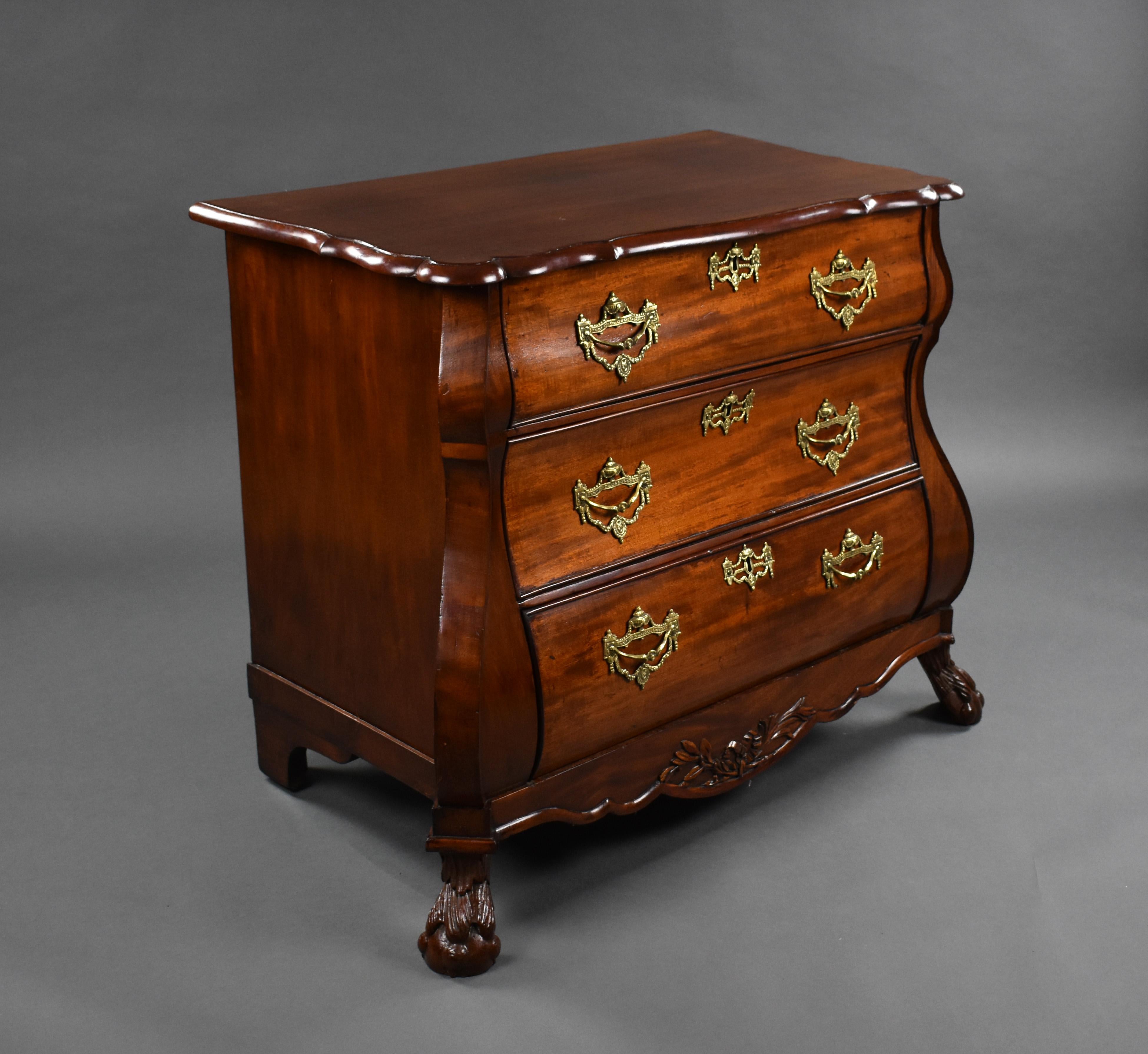 A 19th century Dutch mahogany chest of drawers. The bombe shaped commode chest has a shaped top above three long graduated drawers, each with ornate brass handles and escutcheons, standing on carved claw and ball feet, the chest remains in very good