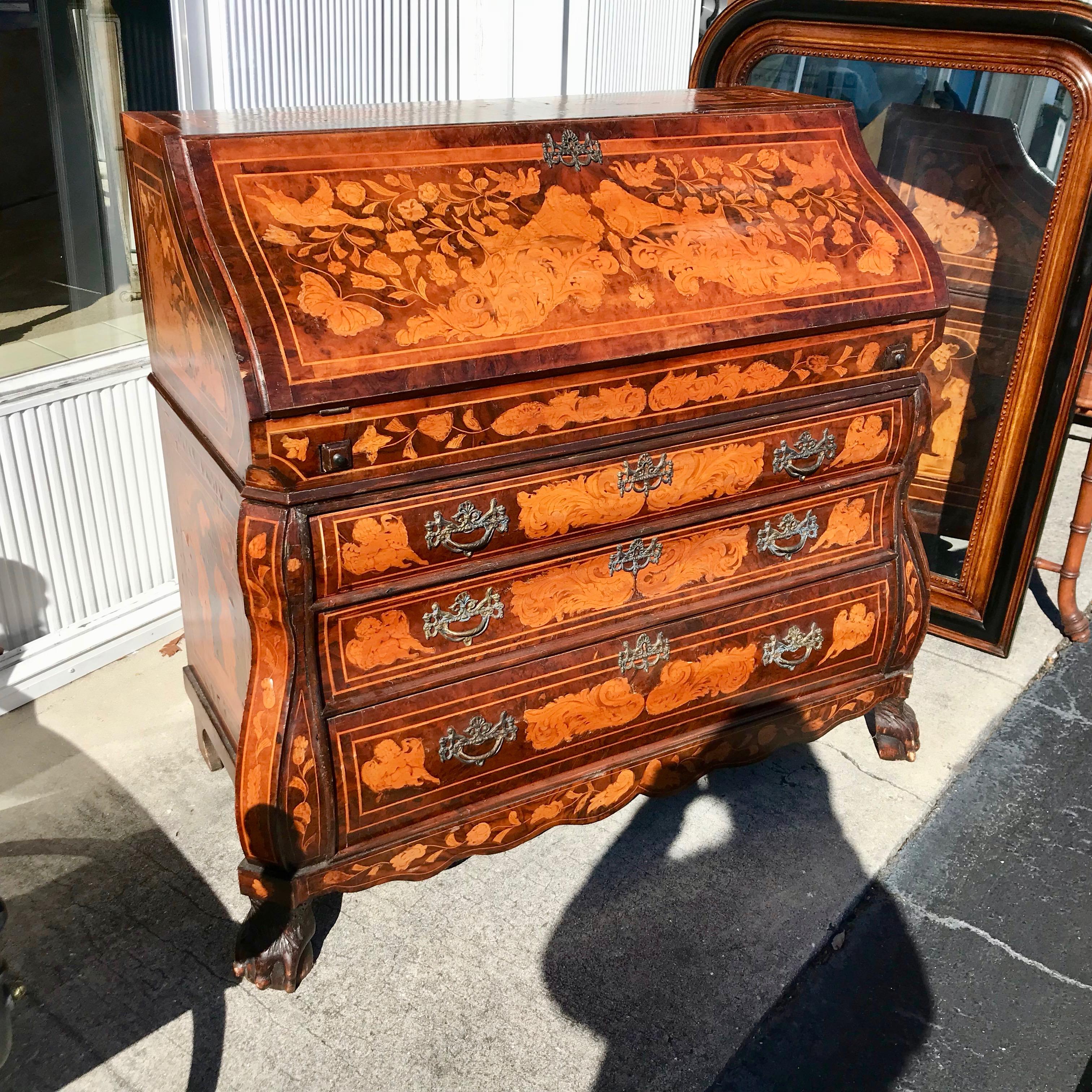 Generously scaled and proportioned with elaborate inlays inside and out -
- both figural and floral. Quality bombe' form.
The desk is raised upon paw feet.
A visually dramatic piece.