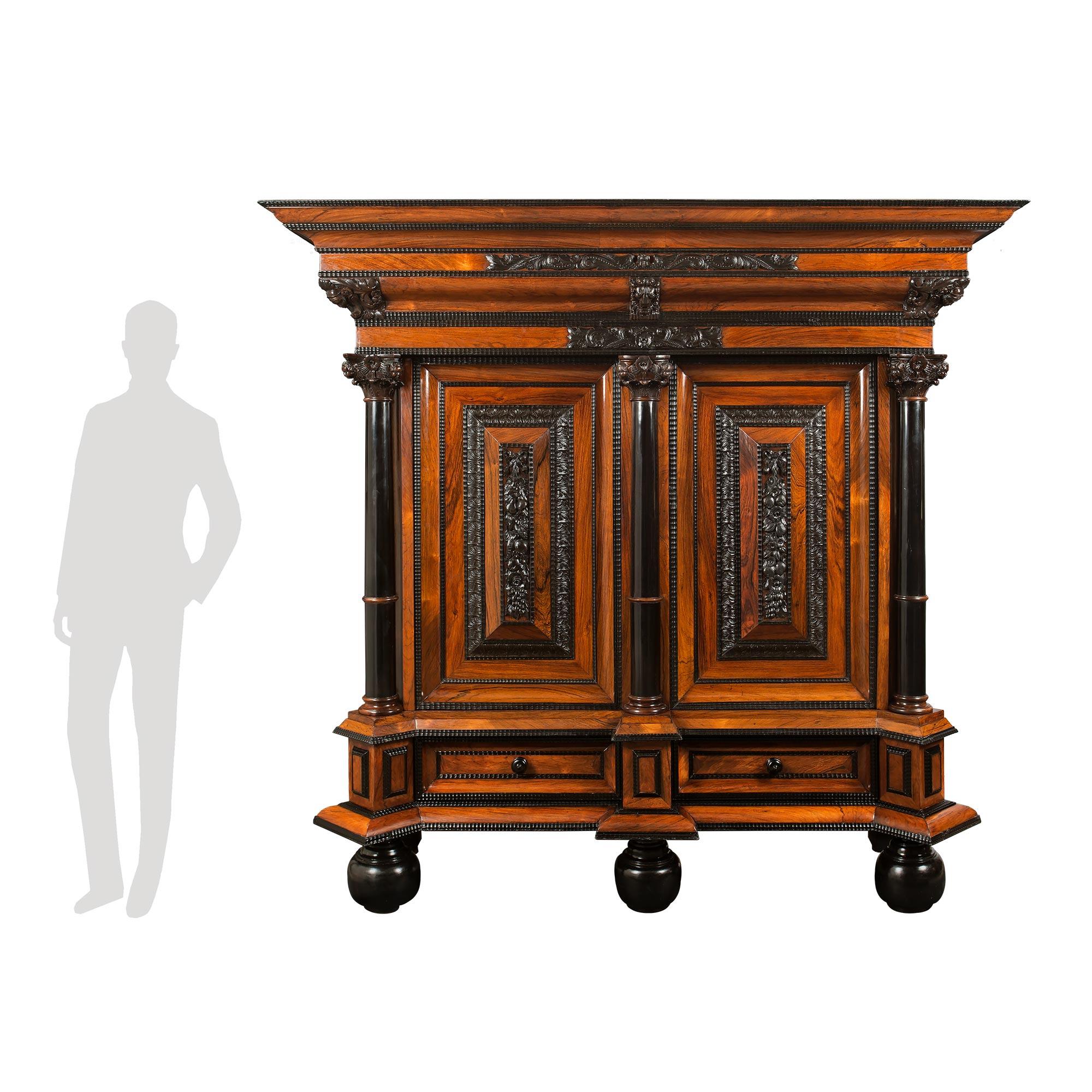 A monumental Dutch 19th century ‘Meubles à Coussins’ ebony and walnut Kussenkast. This most impressive cabinet is raised by bun feet below the dentil shaped frieze. At the bottom of cabinet is a wide drawer with original iron pulls. The raised