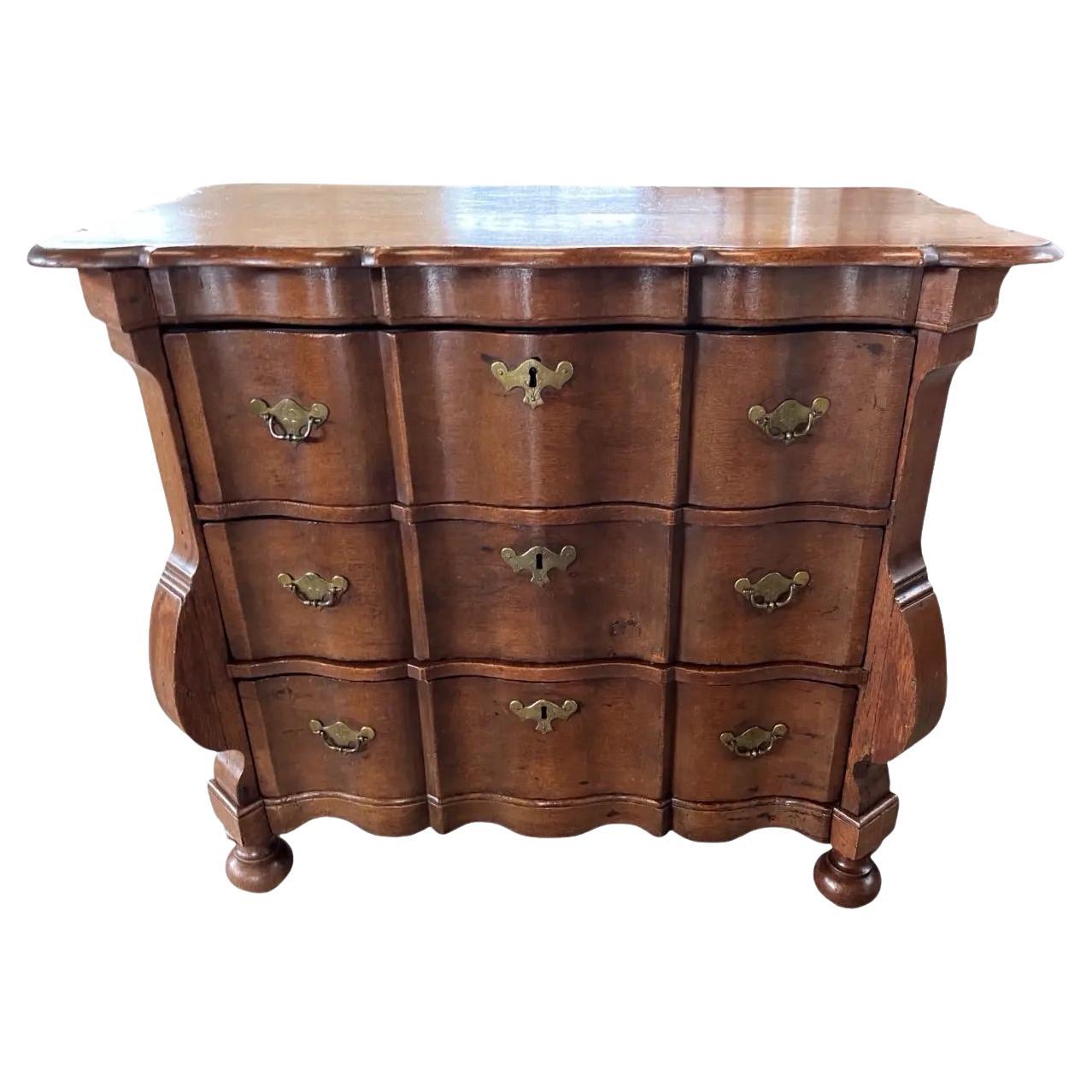 Petto  cassettiera realizzata a mano nei Paesi Bassi all'inizio del 1800 con struttura in Oak e pioli. Il comodino presenta tre cassetti incassati, tutti con i frontali a serpentina. Il piano presenta bordi arrotondati e segue lo stesso motivo a