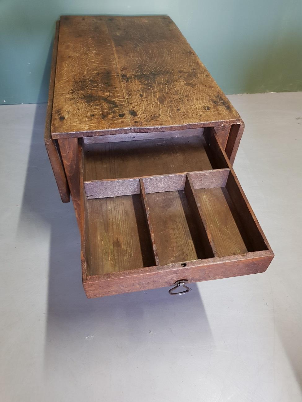 Antique Dutch oak drop-leaf table with drawer and with a very used top that is resulting in a beautiful patina, 19th century.

The measurements are,
Depth 89 cm/ 35 inch.
Width 47-92 cm/ 18.5 - 36.2 inch.
Height 42 cm/ 16.5 inch.