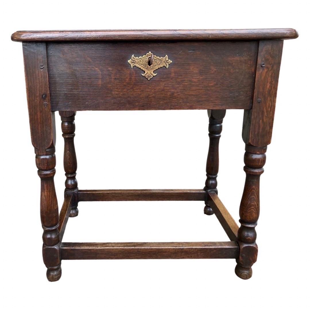 Small 19th century side table made in the Netherlands using oak and pegged construction. This table is interesting because the top opens, providing access to a rather large storage space and it can, therefore, work as a table, stool and container