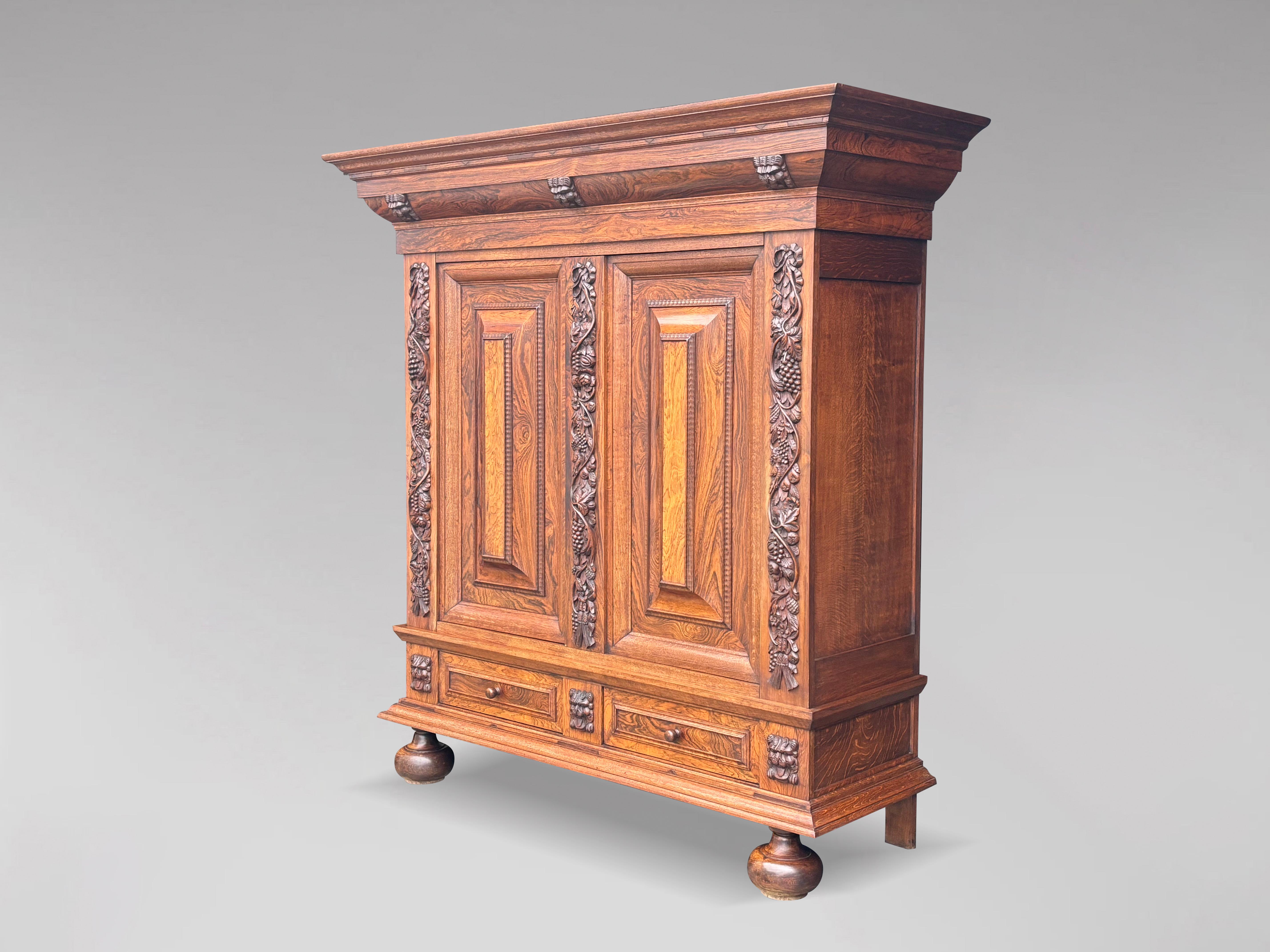 An exquisite antique mid 19th century Dutch cabinet or cupboard in the renaissance style, crafted from the finest rosewood veneers on solid oak. Moulded top cornice, above a frieze of three carved lion masks, the two central doors with deep panels