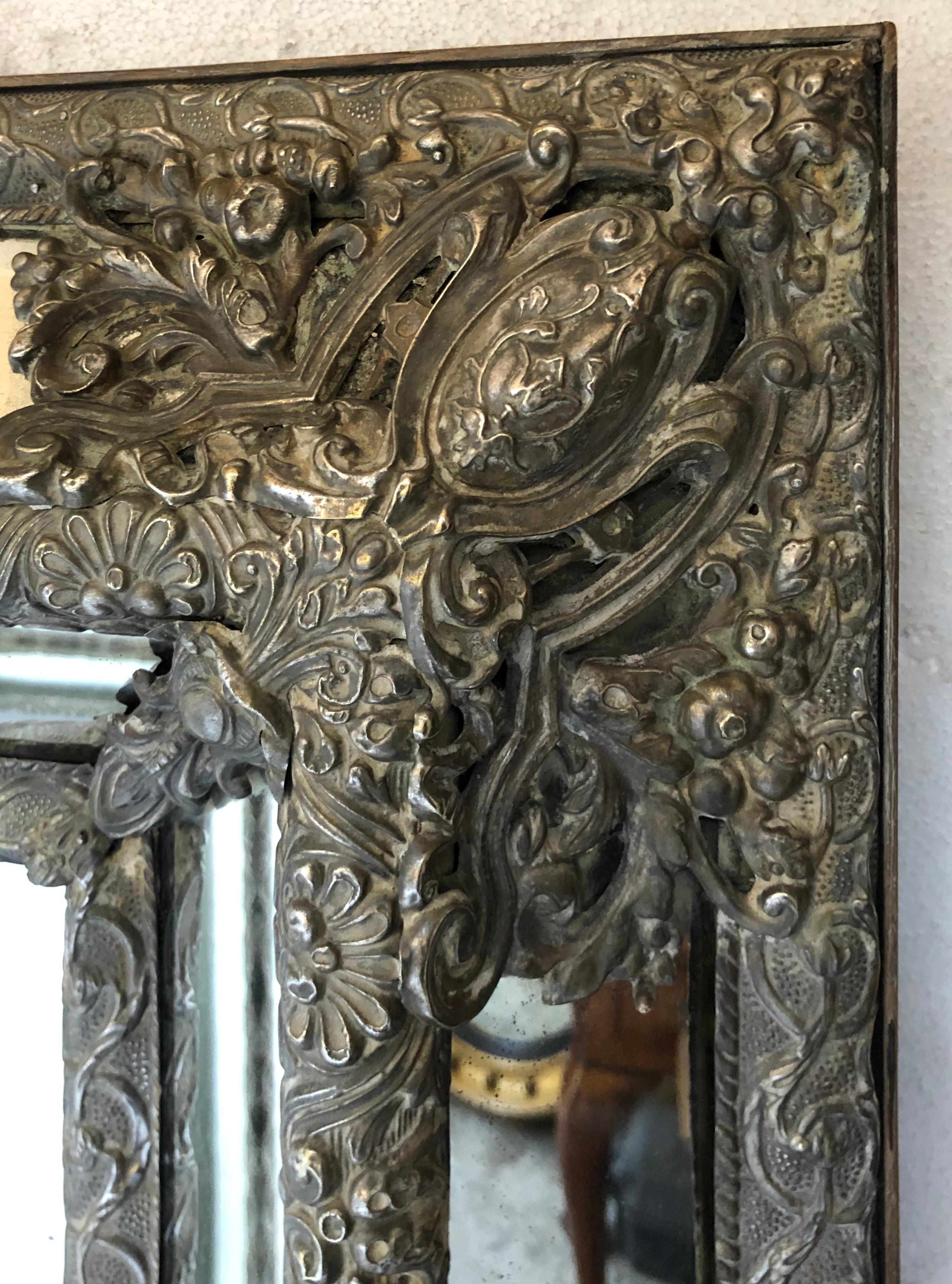 19th century Dutch repousse silvered metal the bevelled rectangular mirror with raised marginal plates the repousse metal work with acanthus and scroll decoration.