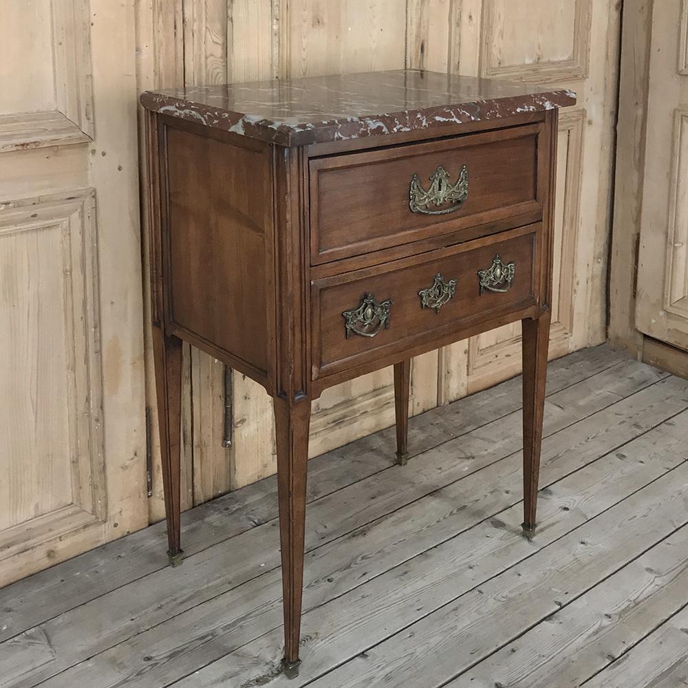 19th Century Dutch rouge marble top commode is crafted from fine solid walnut. Designed with neoclassical inspired architecture, it boasts its original antique intricately cast bronze drawer pulls and key guards decorating the fronts of the drawers,