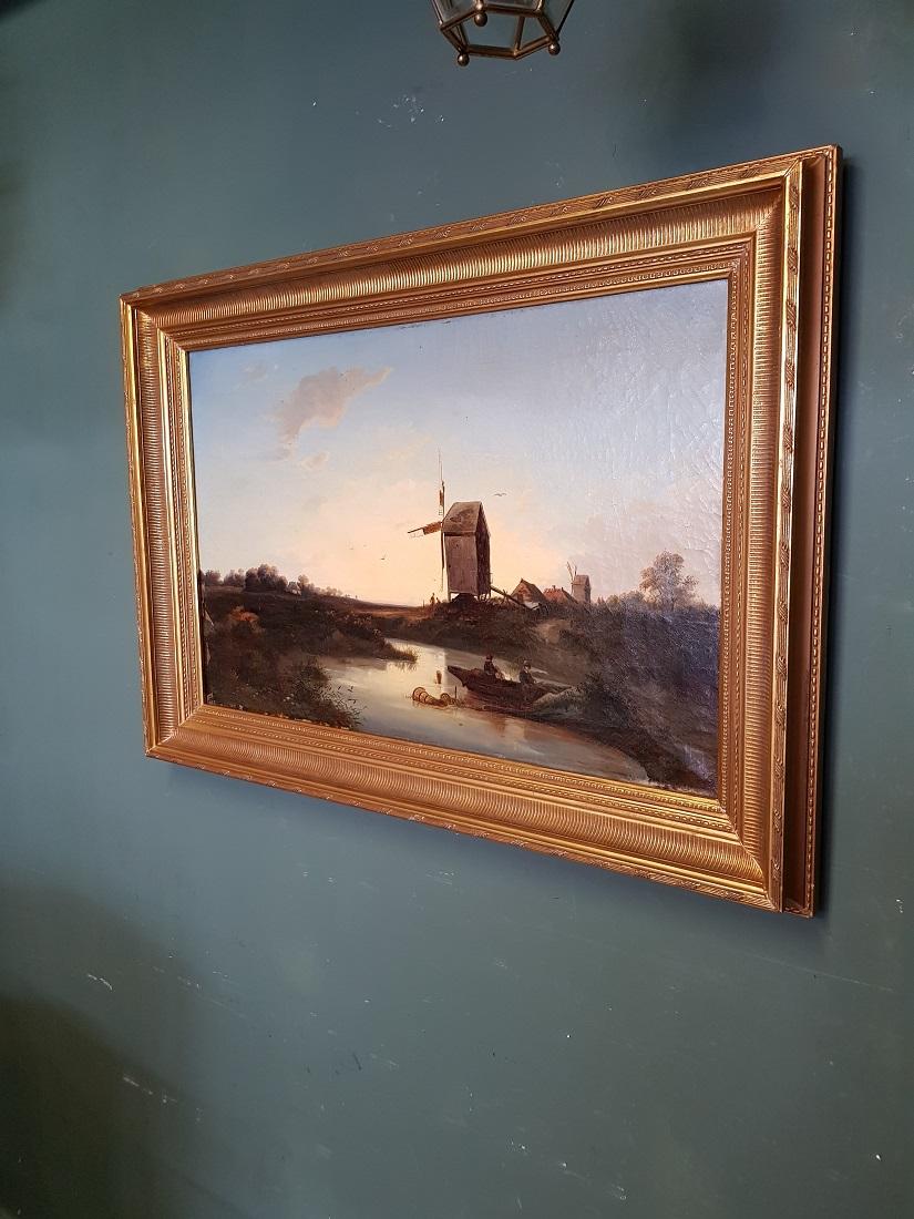 Antique Dutch school oil painting on canvas and attributed to Johannes Hilverdink, depicting a polder landscape of fishermen at a mill in a new gilt frame, it has some paint loss in the left corner and in a reasonable condition around crackle.