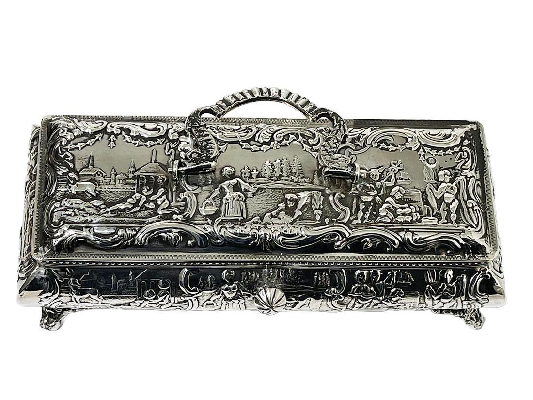 19th century Dutch silver box by Willem van Baren, Schoonhoven, 1886

A silver box with a hinged lid. The handle of the lid are 2 dolphins. The relief surrounds the box with a scene of a landscape with farmers working on the land and a horse and