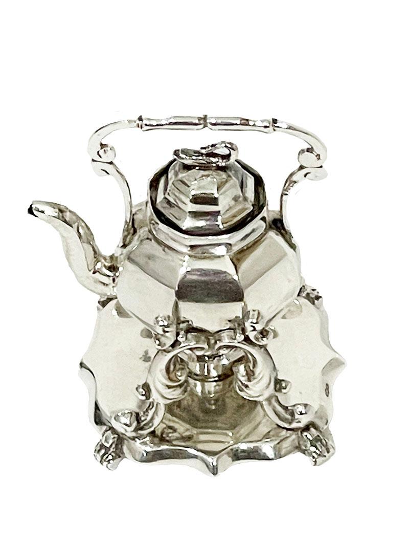 19th Century Dutch silver miniature kettle on stand

A Dutch silver miniature kettle on stand. ( a Bouilloire). The kettle with fixed lid with a swan on it is hanging in the base, which is gracefully decorated with curly leaf motif legs on a base.