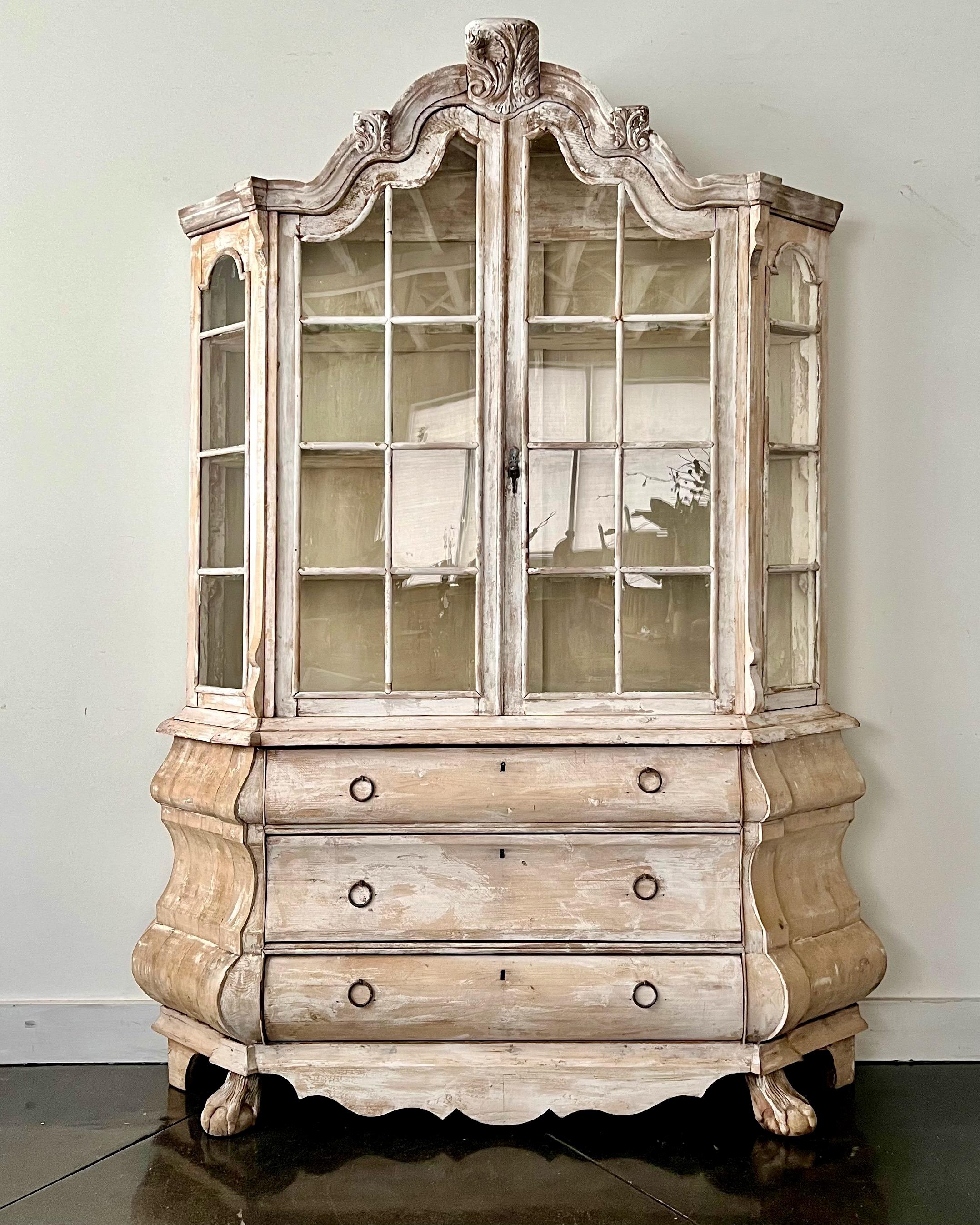 A very elegant 19th century Dutch cabinet vitrine in impressive scale with richly carved crest with acanthus leaves, and scrolls., scraped to its most original patinated color, beautifully shaped/scalloped interior shelve, arched pediment cornice