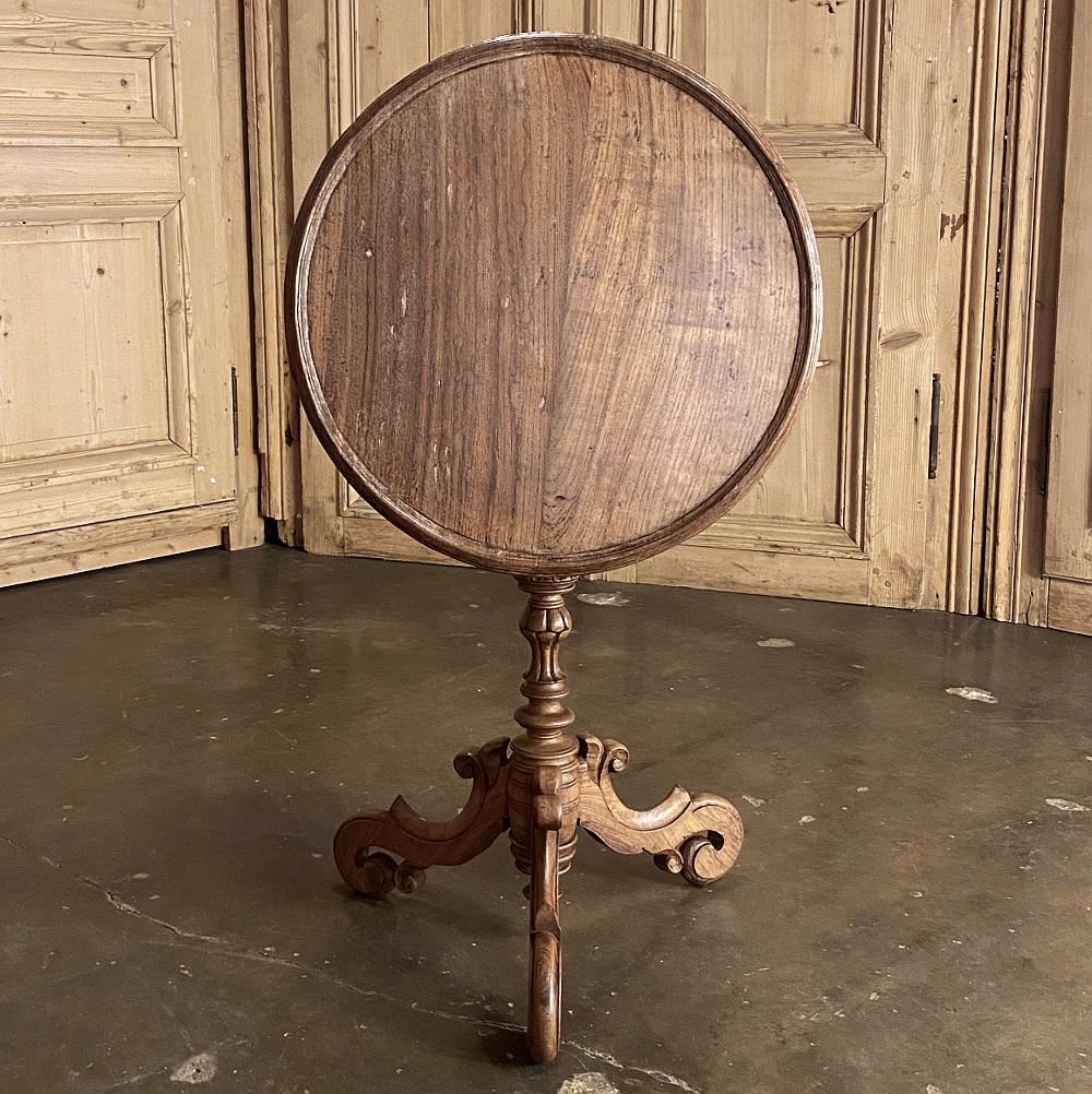 19th century Dutch walnut tilt top end table represents the refinement of furniture craftsmanship in Western Europe melded with the traditional entertaining rituals of the more affluent. Using sumptuously grained walnut, a round top with molded rail