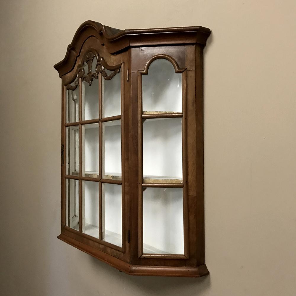 19th century Dutch wall vitrine is ideal for displaying a particularly notable family heirloom, collection, or just nice things you want to keep at arm's reach! Glass panes on all three sides allow natural light in, and the arched crown with hand