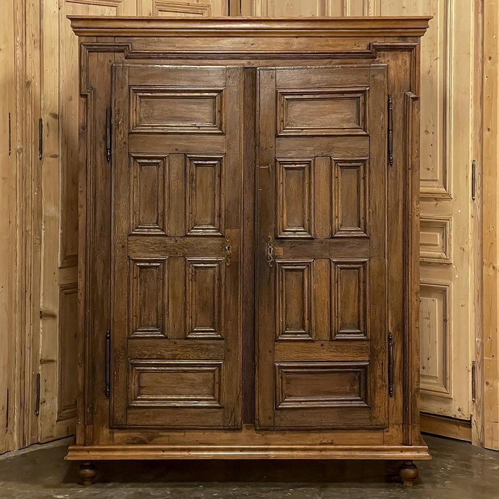 19th Century Dutch wardrobe ~ armoire will make the perfect choice for the tailored, casual or rustic decors! Hand-crafted from solid oak, it features a rectilinear theme with six molded panels on each door and the doors themselves surrounded by
