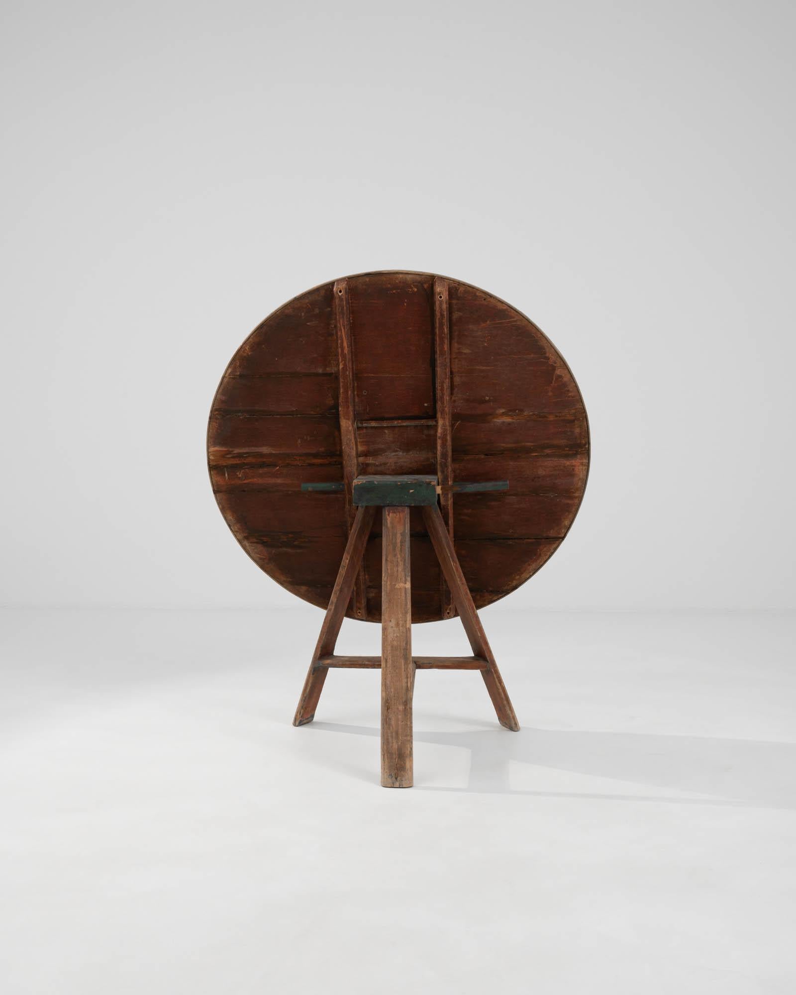 Introducing the 19th Century Dutch Wooden Wine Tasting Table – a piece that instantly conjures images of conviviality and the rustic charm of a bygone era. This unique table, with its circular top and cleverly hinged construction, was a fixture in