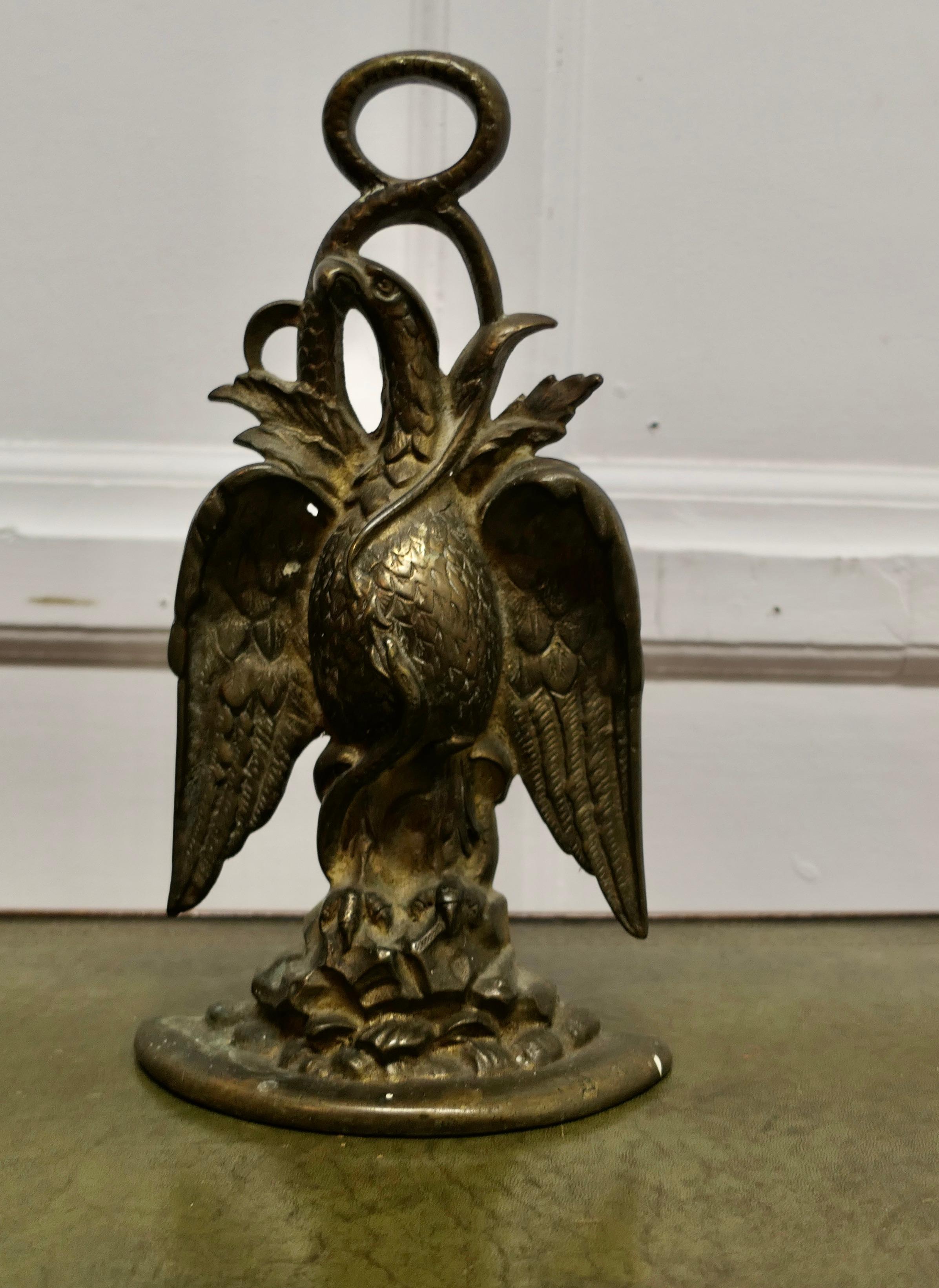 19th Century Eagle & Serpent Brass Door Stop 

Needless to say a heavy piece, is age darkened, the Eagle and snake fighting symbolise two sides of a conflict
At the top the handle of the Door Porter is formed by the body of the snake,
All in good
