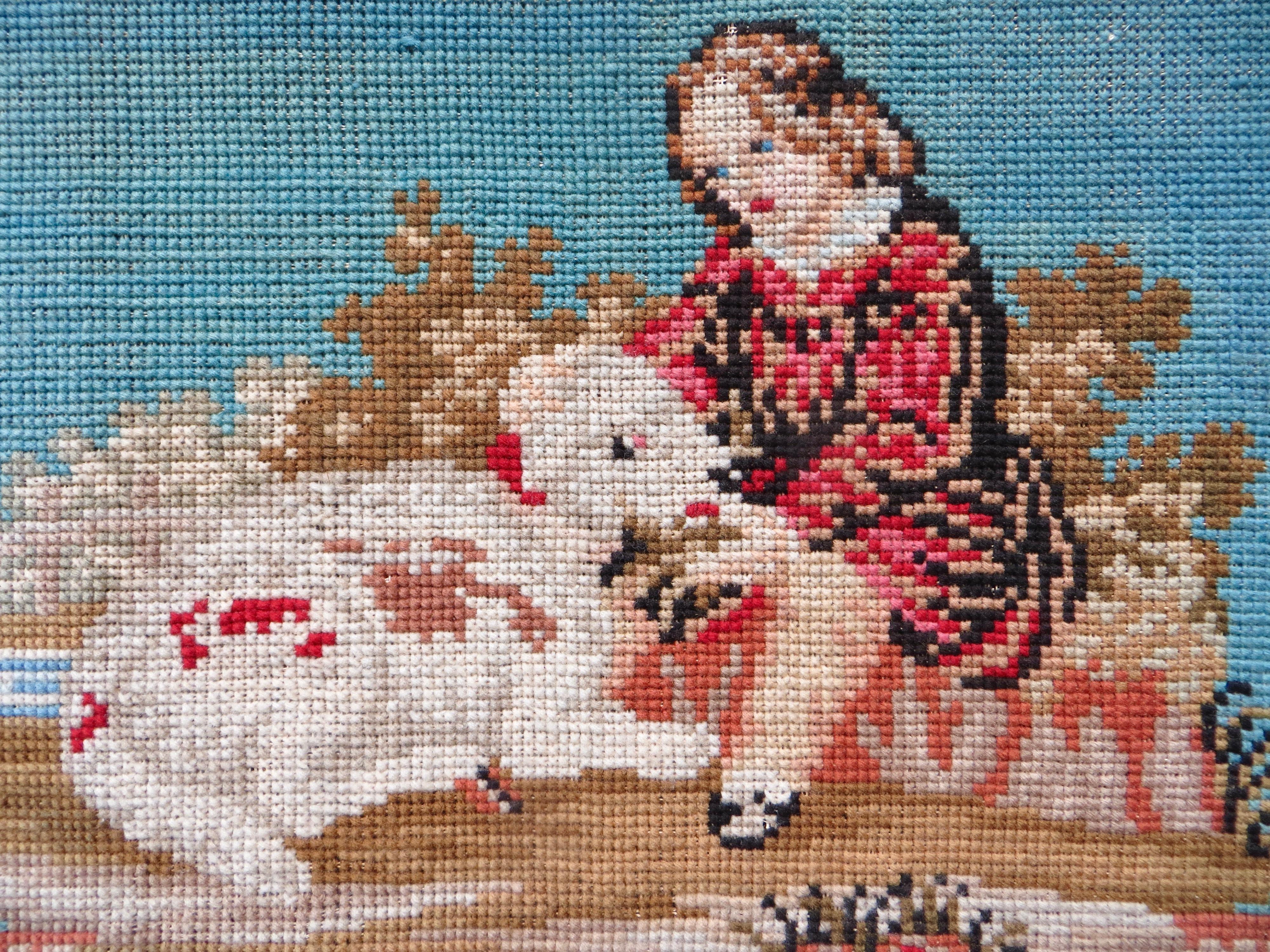 Cette tapisserie à l'aiguille authentique du début de l'époque victorienne présente un jeune garçon aux longs cheveux blonds portant des vêtements traditionnels du début de l'époque victorienne, assis dans un champ pastoral de couleur beige et