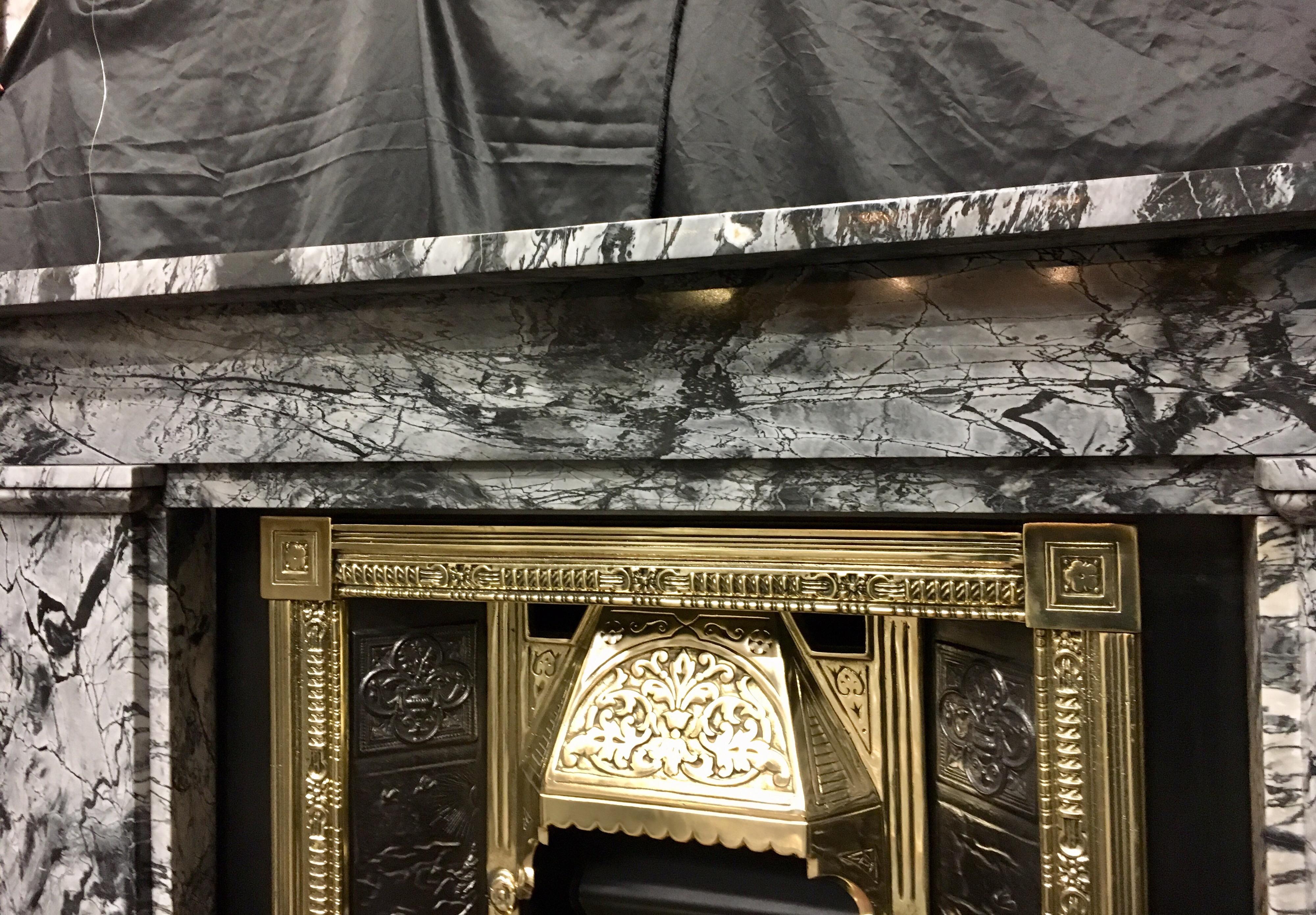 A 19th century antique early Victorian grey Bardiglio Forito marble fireplace surround from the quarry in Serravezza, Italy.
A square shelf sits directly above an unadorned stepped through frieze, flanked by substantial stepped jambs with moulded