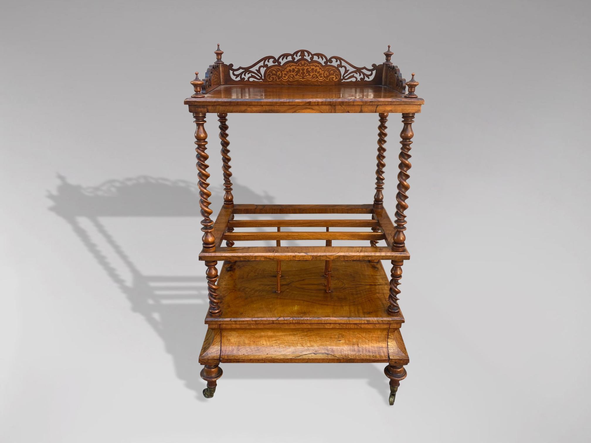 A 19th century, early Victorian period walnut and inlaid Canterbury whatnot music stand, barley twist supports, with blind frieze drawer to the cavetto base, all standing on 4 elegant feet terminating on brass castors. England circa 1850. Gorgeous