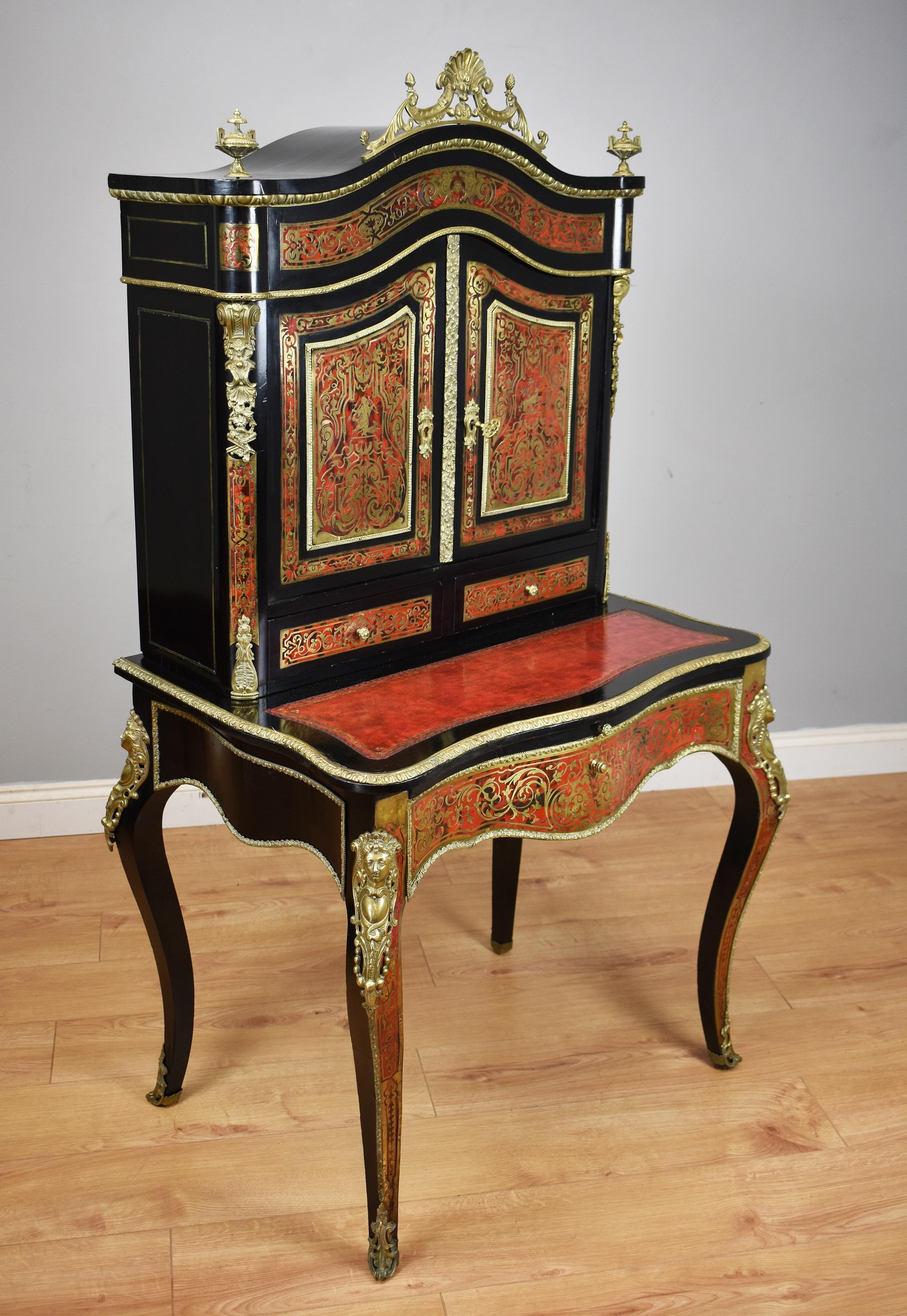 For sale is a fine quality 19th century ebonised Boulle Bonheur Du Jour writing table. The top, of arched form, has an ornate brass pediment, flanked by a brass urn shaped finial on either side. Below this the two doors, each profusely inlaid with