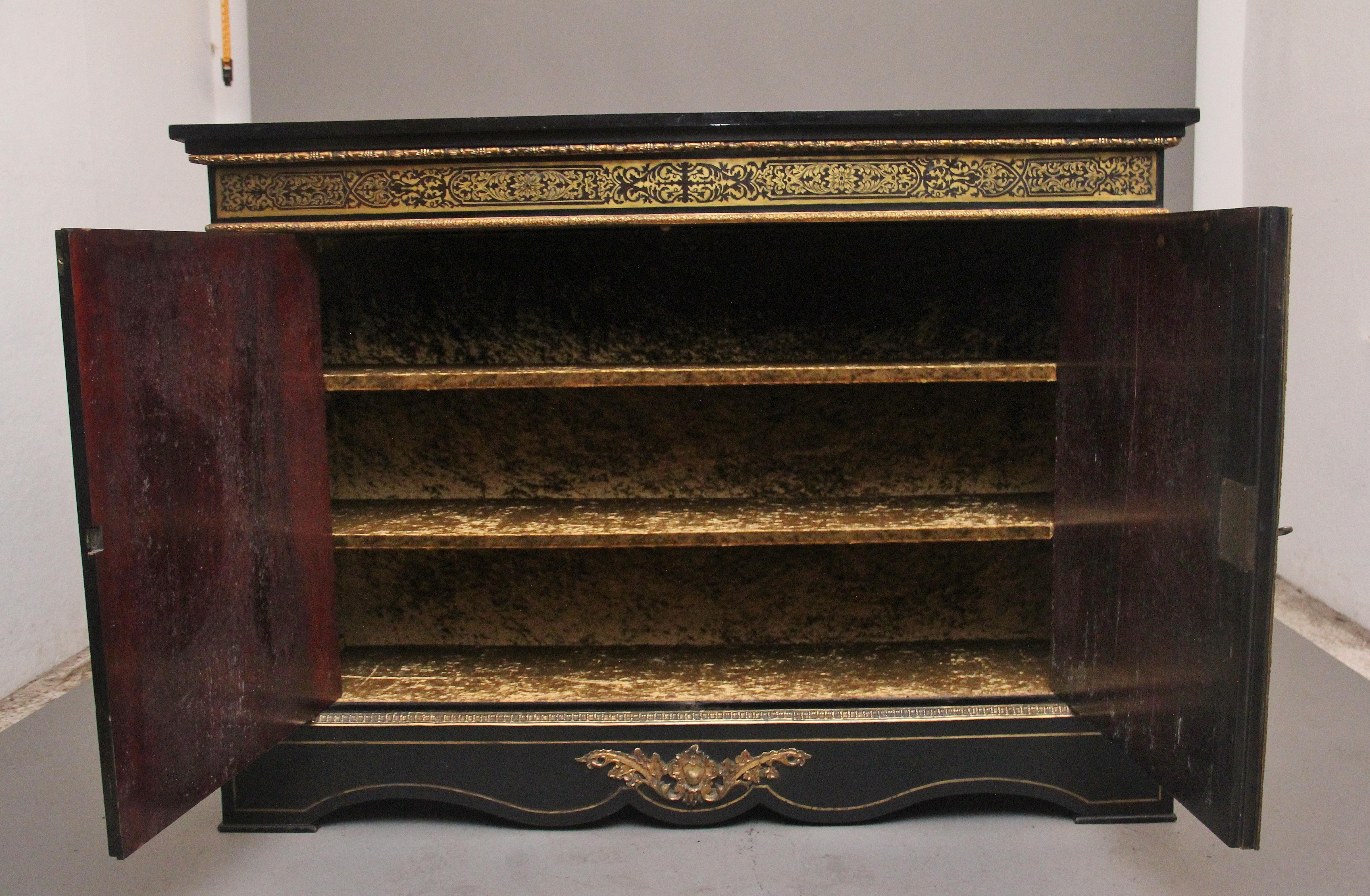 Armadio a due ante in ebanizzato, boulle e ormolu della metà del XIX secolo di qualità superba. Il piano rettangolare in ebanizzato sovrasta un fregio con bordature in ormolu che corrono lungo la parte superiore e inferiore con boulle intricate e