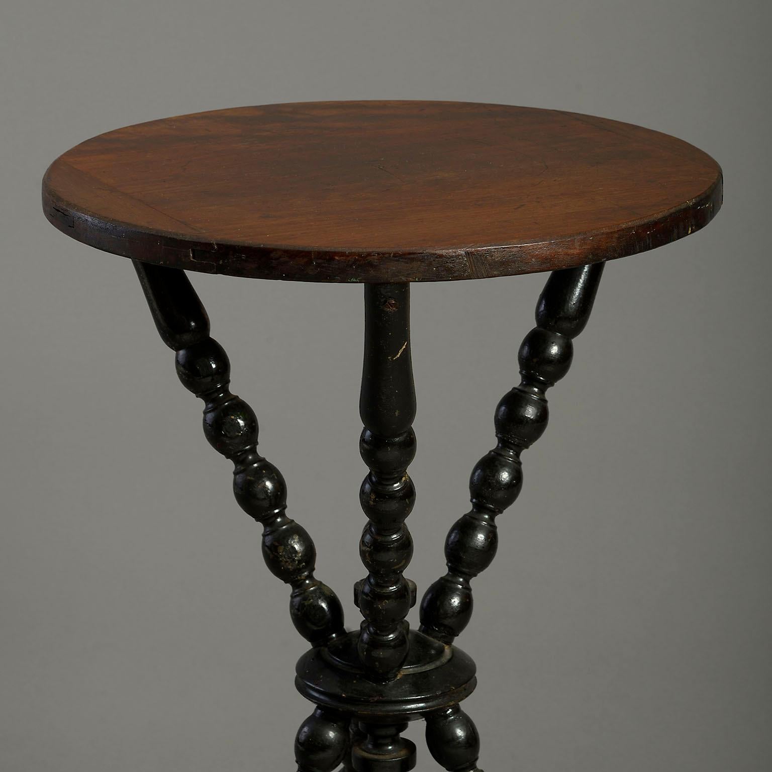 A late 19th century gipsy table, the circular ebonised top set upon three bobbin turned legs with central finials.

