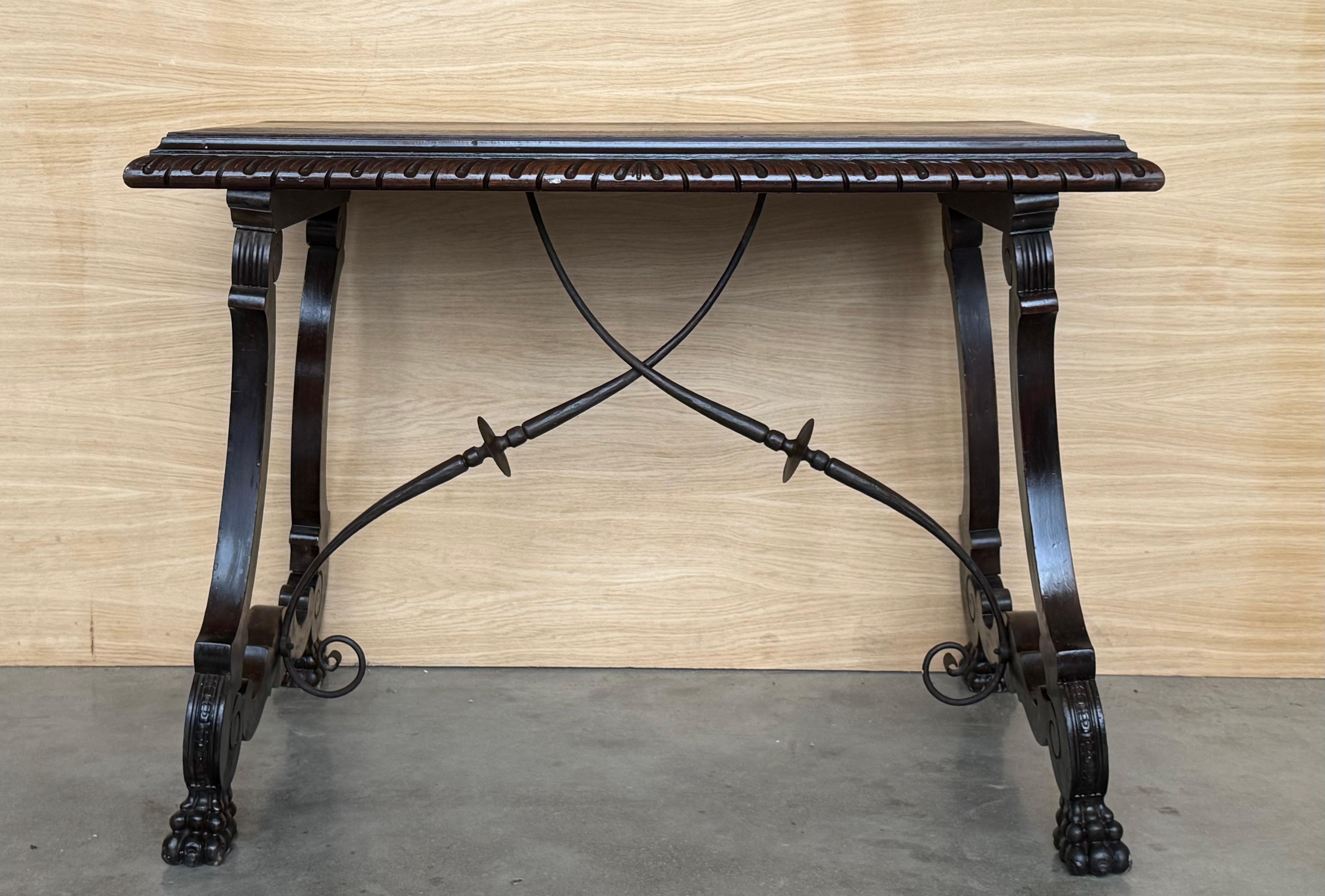 19th century Spanish trestle table in walnut. This piece has a great scale, lovely carved lyre legs and beautiful ebonized top. 
The tables has carved edges front in all sides.
This table could be used as an end table, nightstand, side table or