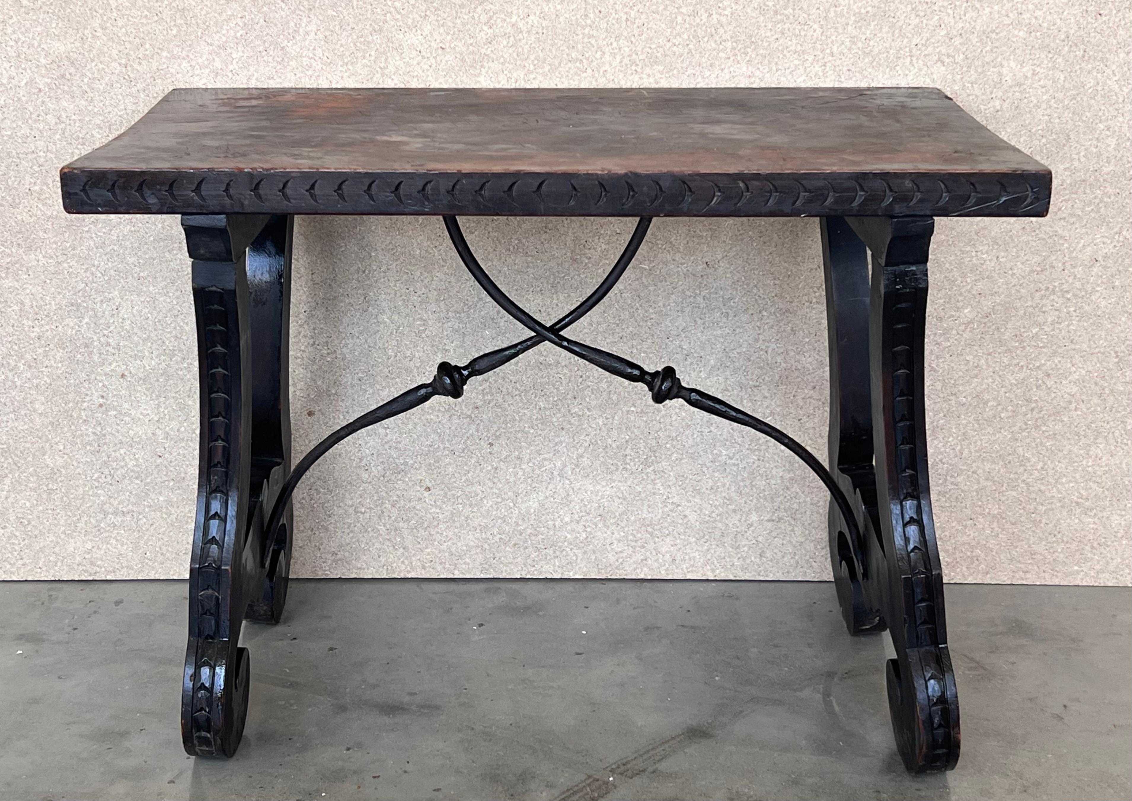 19th century Spanish trestle table in walnut. This piece has a great scale, lovely carved lyre legs and beautiful ebonized top. 
The tables has carved edges front in all sides.
This table could be used as an end table, nightstand, side table or
