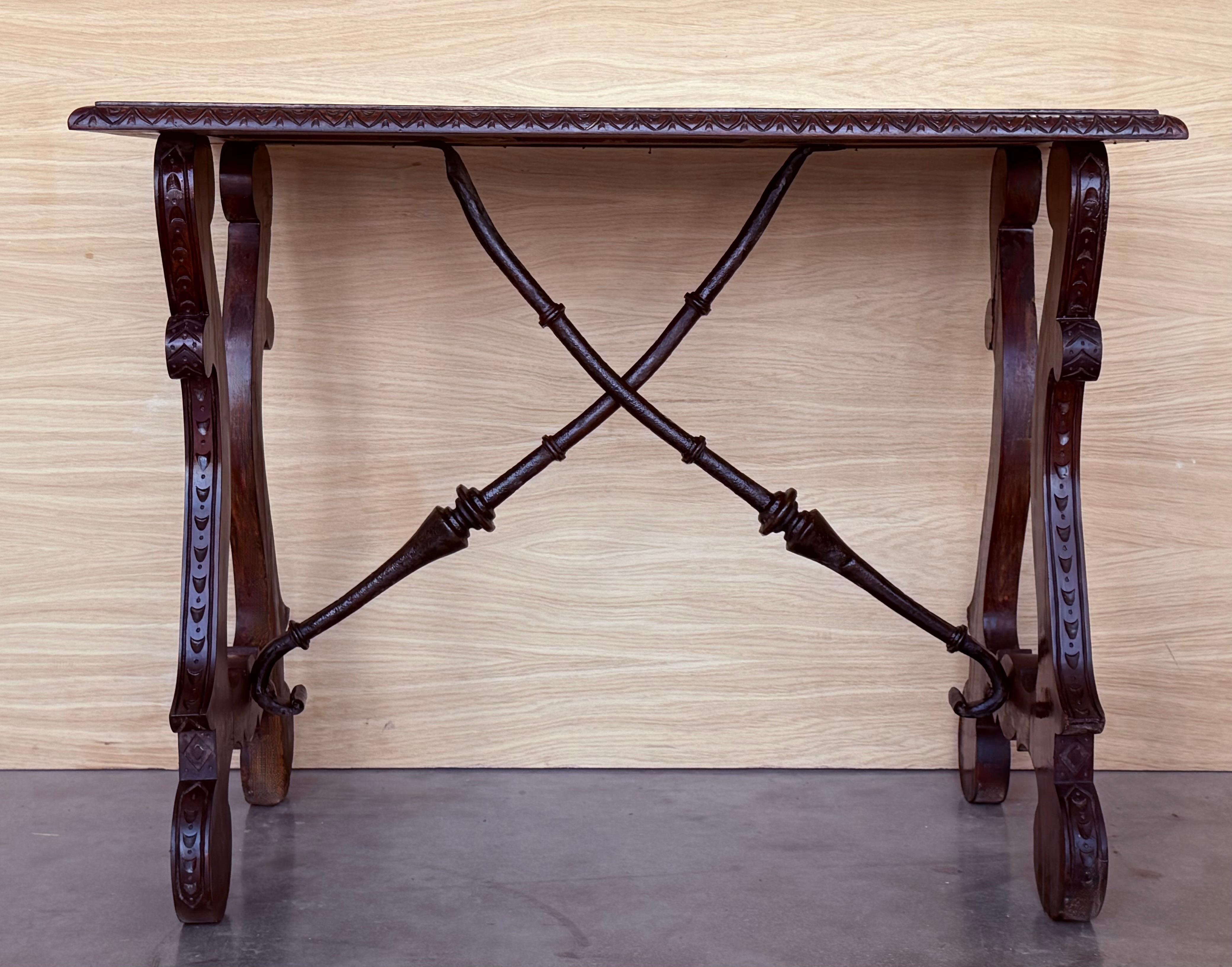 Table à tréteaux espagnole du 19e siècle en noyer. Cette pièce a une grande envergure, de jolis pieds lyre sculptés et un magnifique plateau ébonisé. 
Les tables ont des bords sculptés sur tous les côtés.
Cette table peut être utilisée comme table