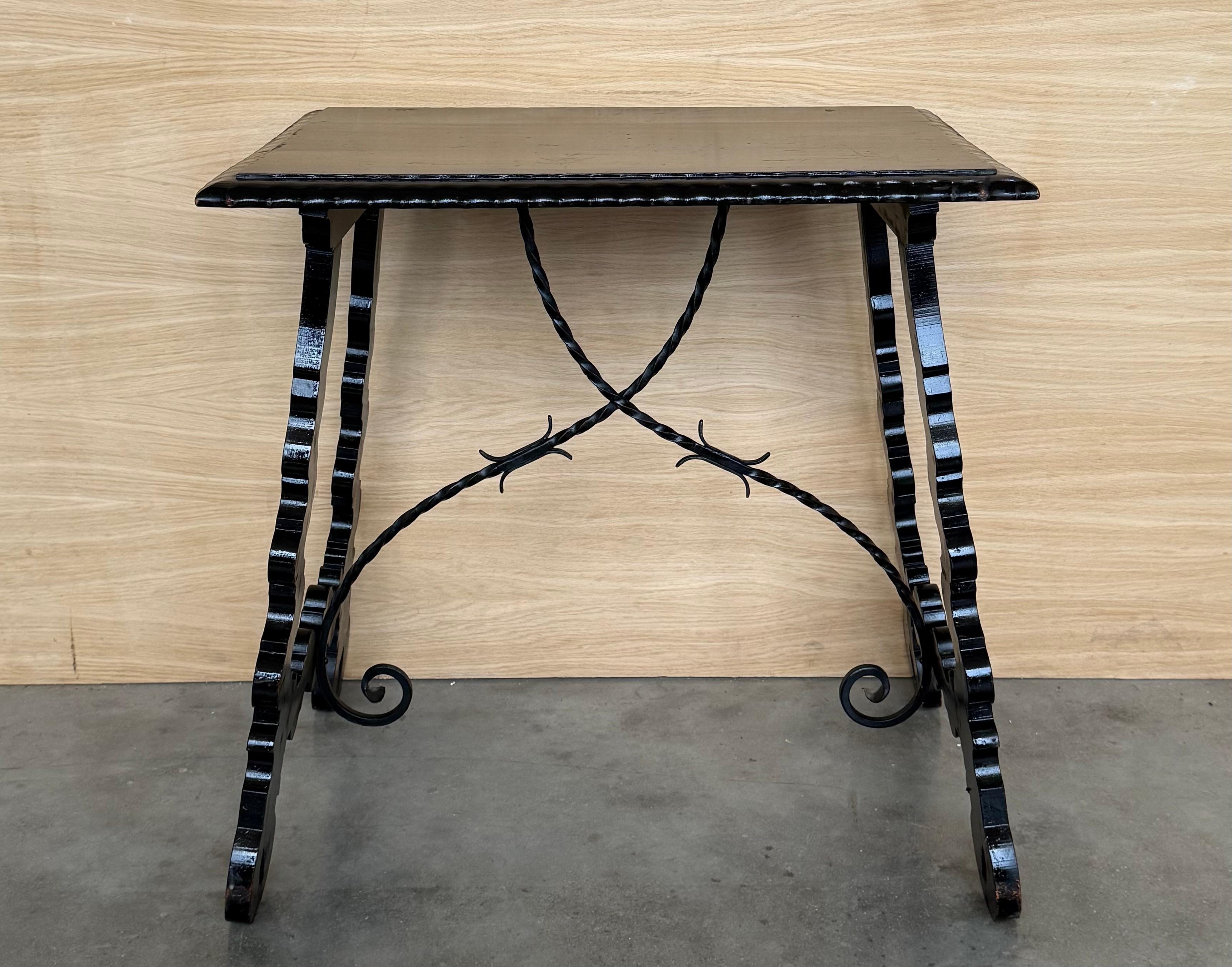 19th century Spanish trestle table in walnut. This piece has a great scale, lovely carved lyre legs and beautiful ebonized top. 
The tables has carved edges front in all sides.
This table could be used as an end table, nightstand, side table or