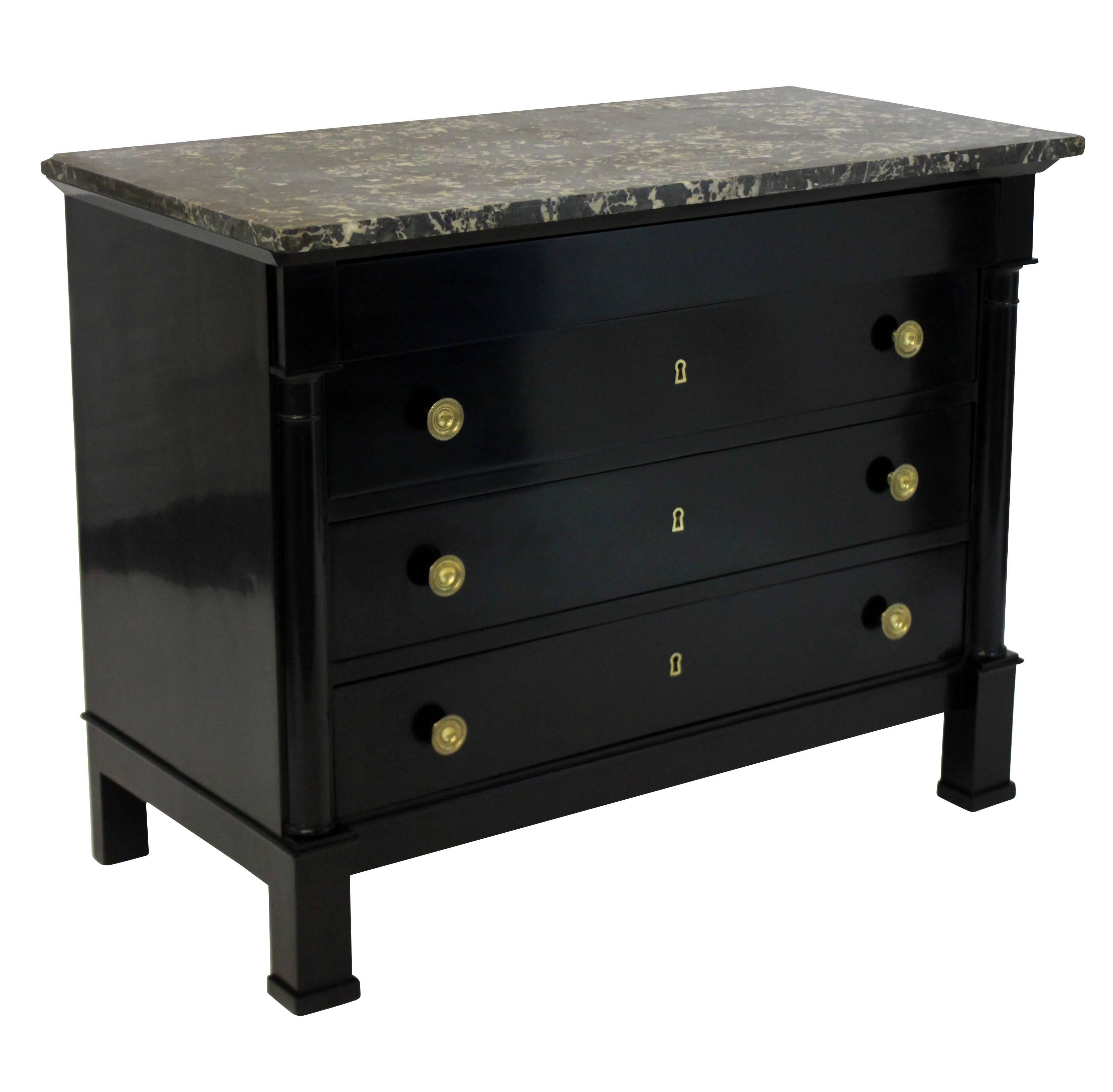 An ebonized mahogany French commode consisting four drawers, with brass handles, bone key surrounds and a good handcut dark grey marble top.
     