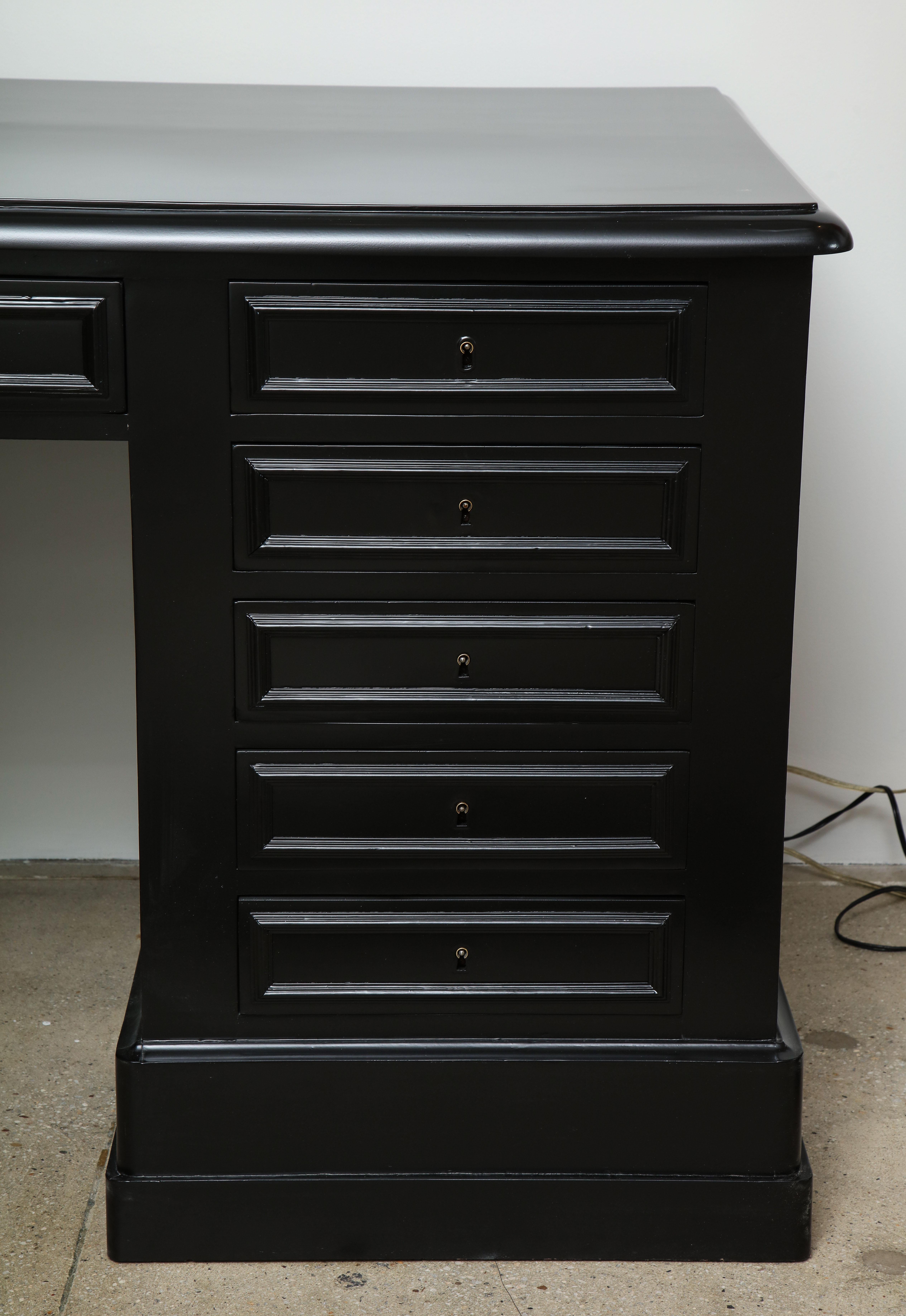 19th century ebonized Napoleon III desk, polished top, pedestal base containing five drawers on either side.