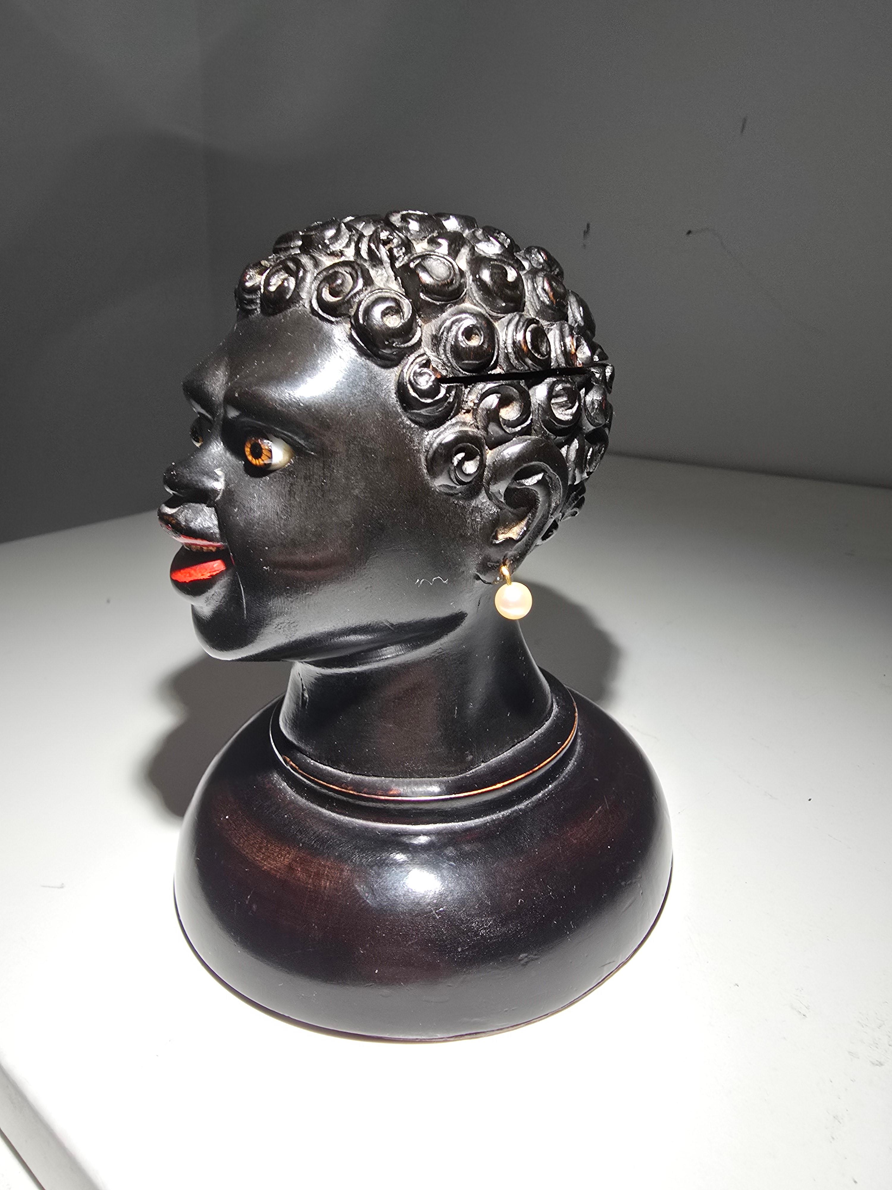 This unique and captivating 19th-century writing desk set combines function with artistic beauty. Crafted from ebonized wood, this remarkable piece is designed as the head of an African figure, showcasing delicate carving and attention to detail.