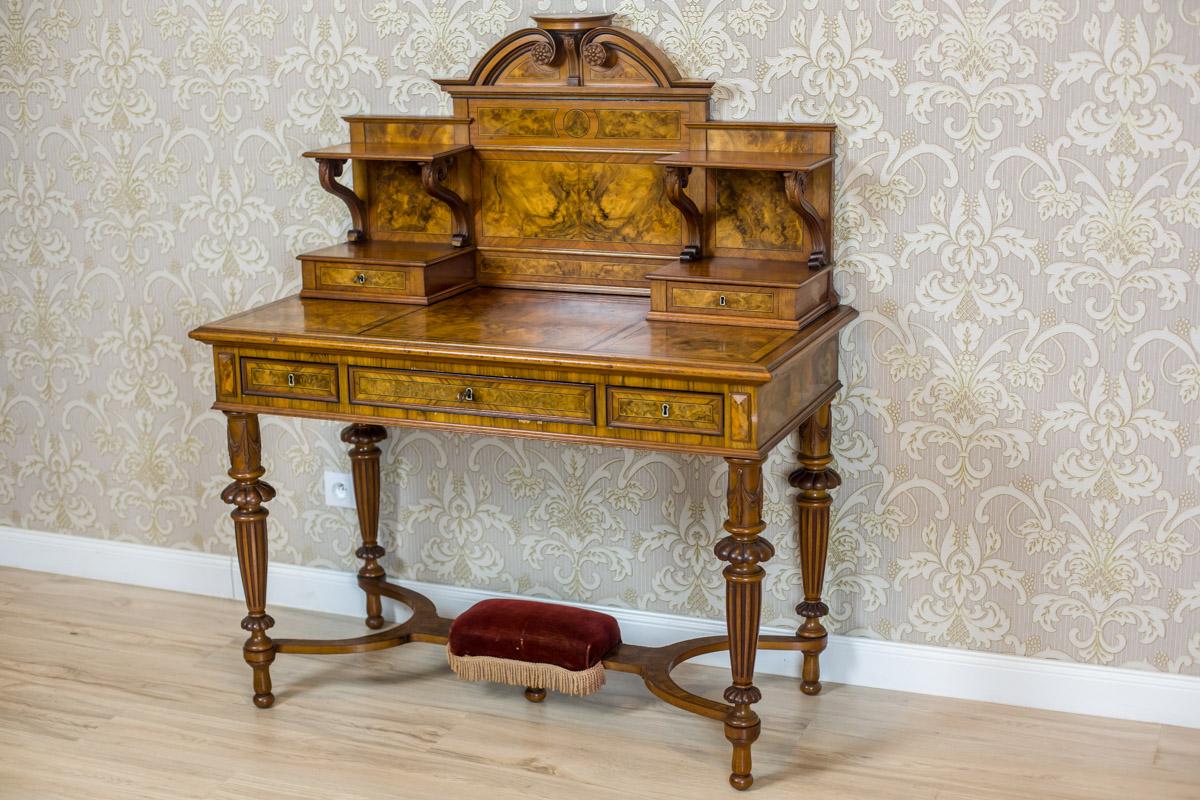 We present you this piece of furniture, circa the late 19th century, made of walnut wood and burl.
The rectangular top of the desk is supported on turned legs; on top, with an add-on unit topped with a crest in the shape of the so-called swan
