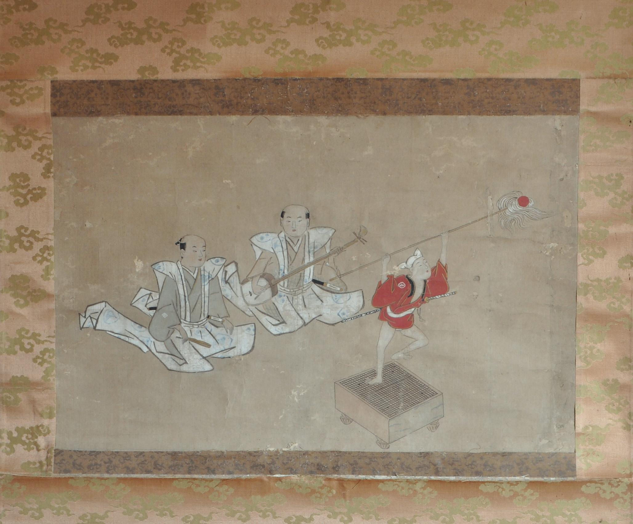 Description - Rouleau suspendu représentant une scène surréaliste de musique et de danse avec deux samouraïs assis et un enfant acteur sur un plateau de jeu de go qui joue le rôle d'une petite marionnette dansante en tant qu'accompagnateur d'un