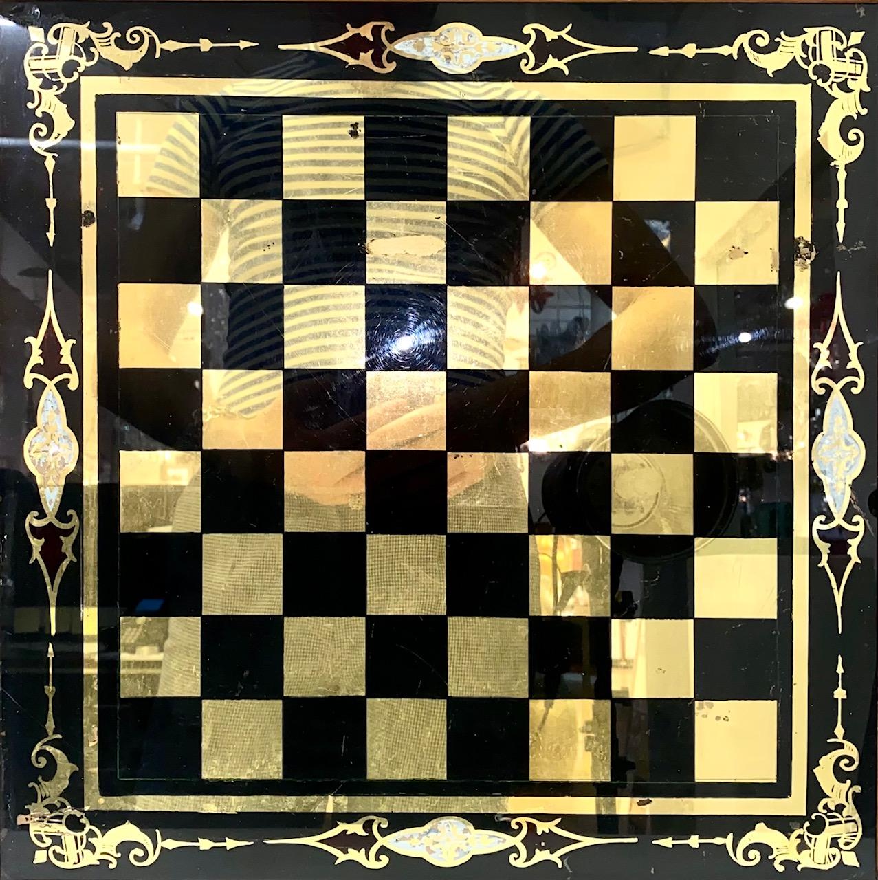 19th century eglomise mirrored chessboard framed in wood, made in the 1870s. Elaborate blue and gold decorations around the chessboard. Small nick on the wood frame, but otherwise in good antique condition. 

Dealer: R316TF.