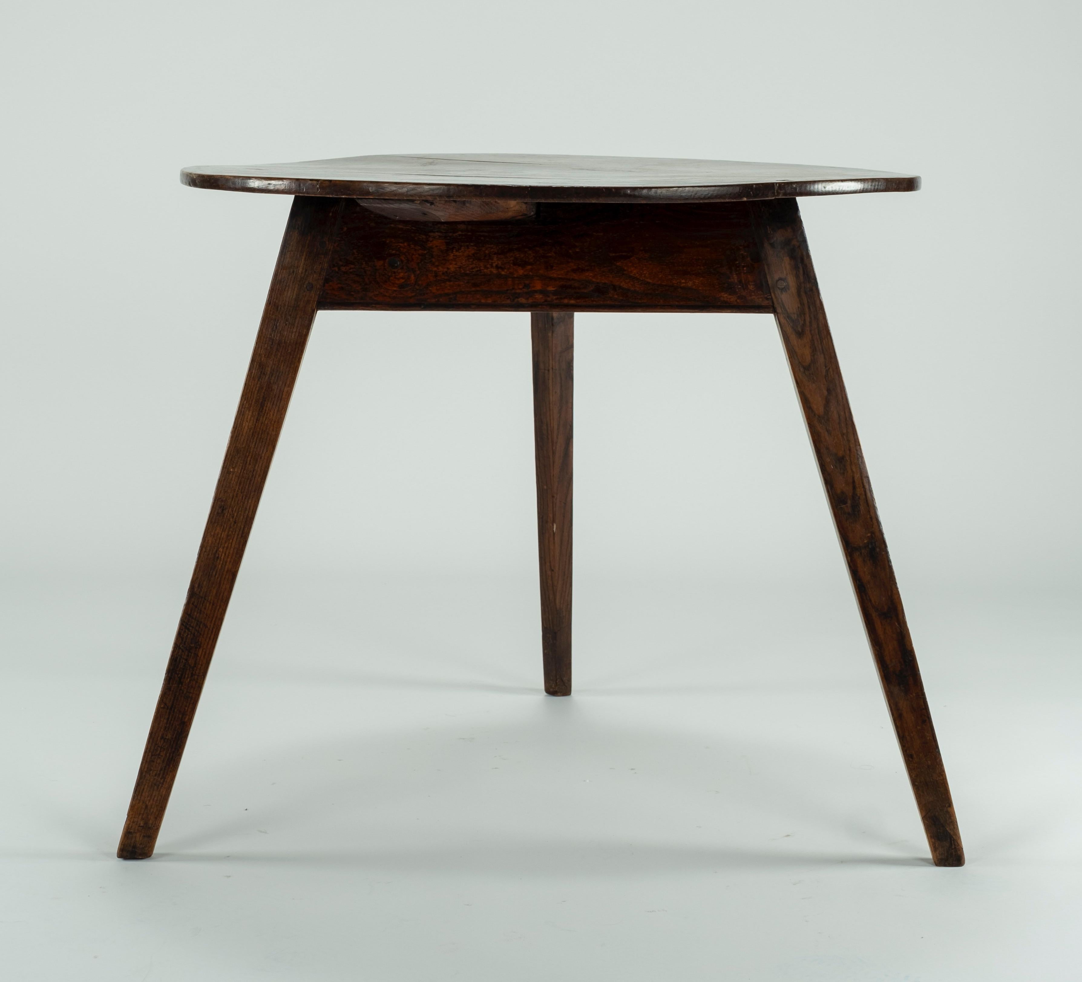 19th century elm cricket table with flat apron and 3 splayed triangular shapes slightly tapering legs.