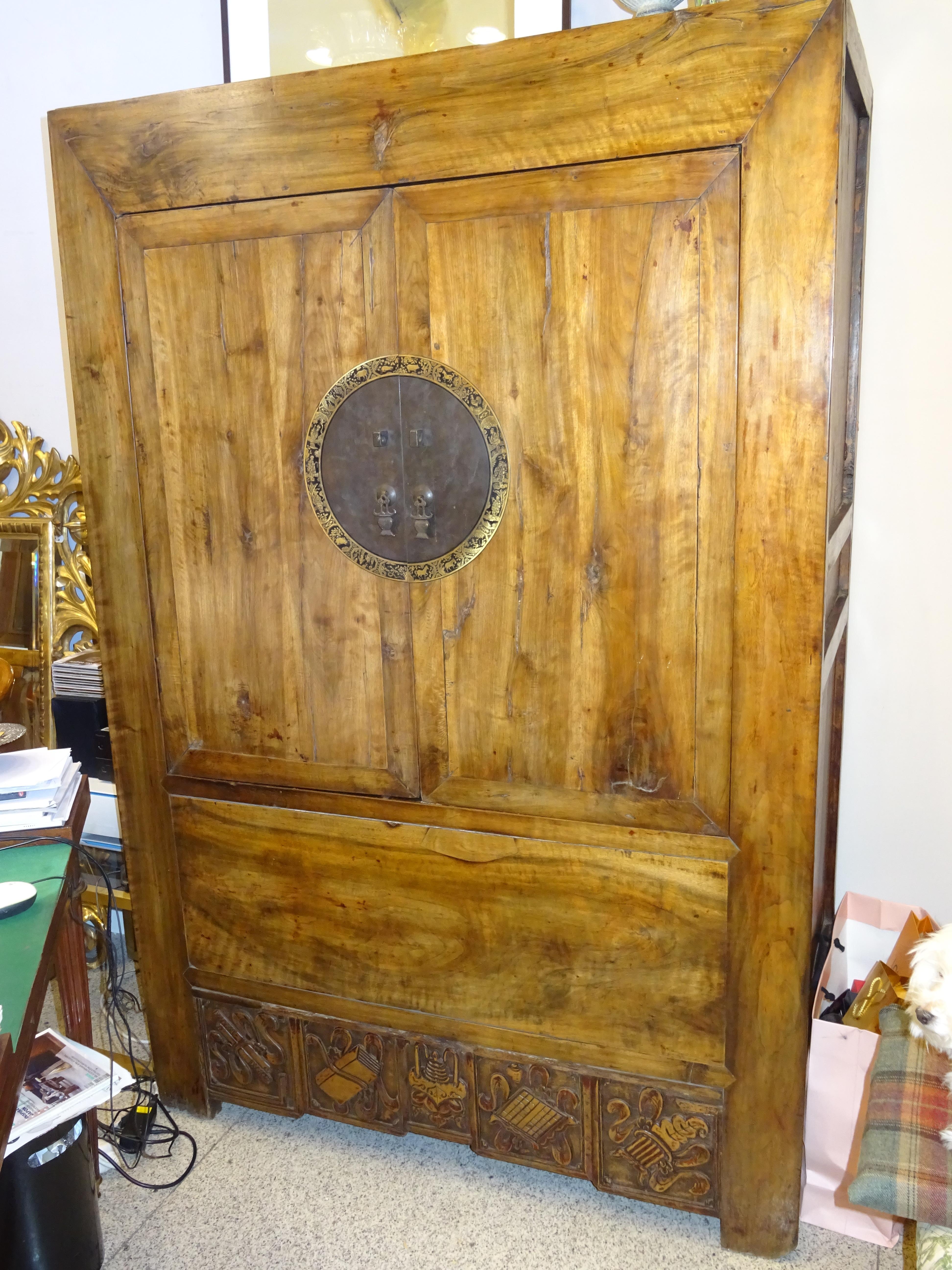 Stunning elmwood and brass Chinese wardrobe with clean lines and a clean and robust profile.
It has 2 doors and inside there is a shelf and a space for a chest or trunk.
In the lock there is a circle in golden brass with the signs of Chinese