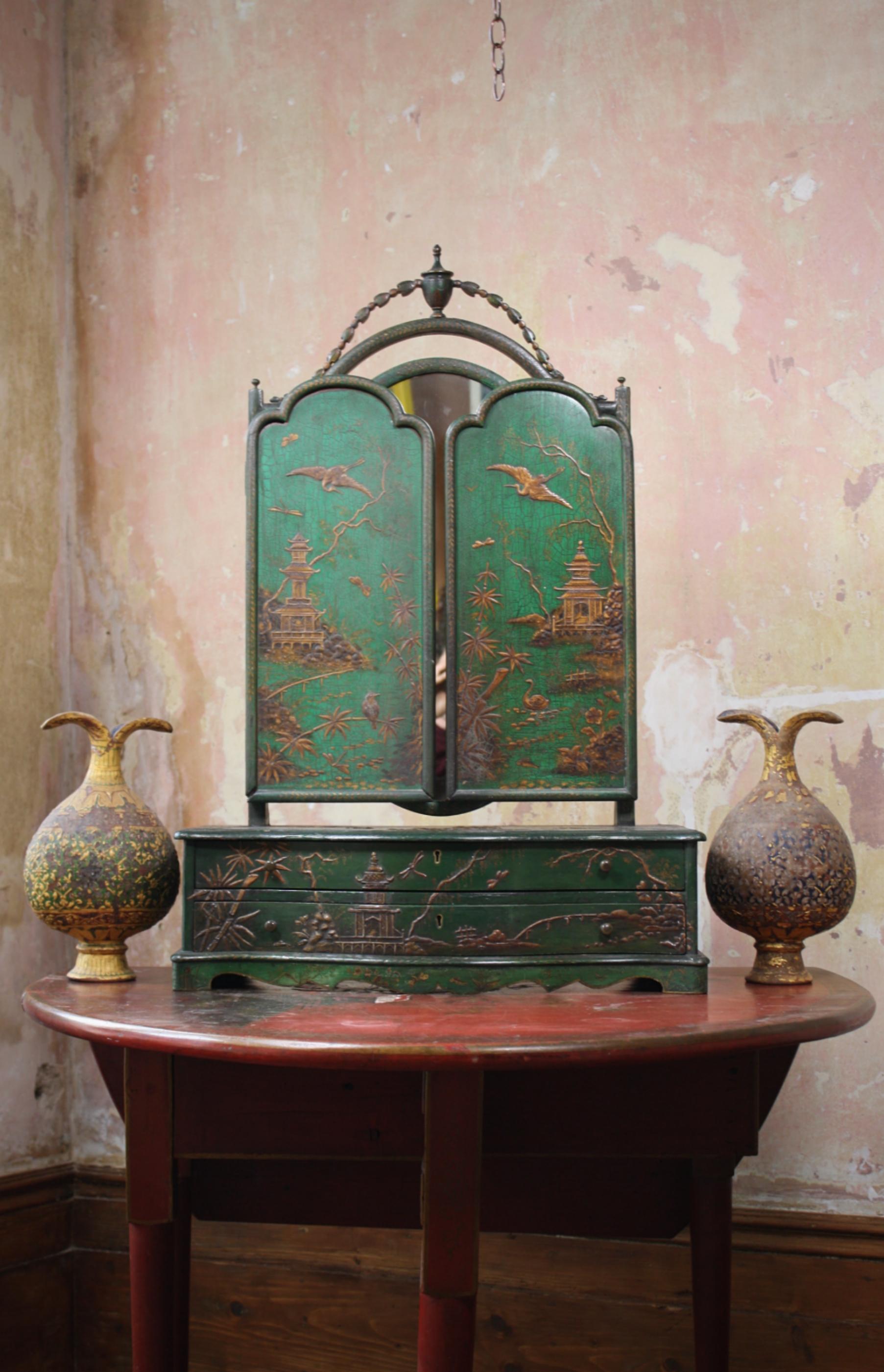 A rather wonderful 19th century Chinese export dressing table mirror, emerald green ground with gilt decoration and a triptych of elegant mirrors. Decorated with typical foliage, birds and traditional architecture.

A pair of serpentine drawers,