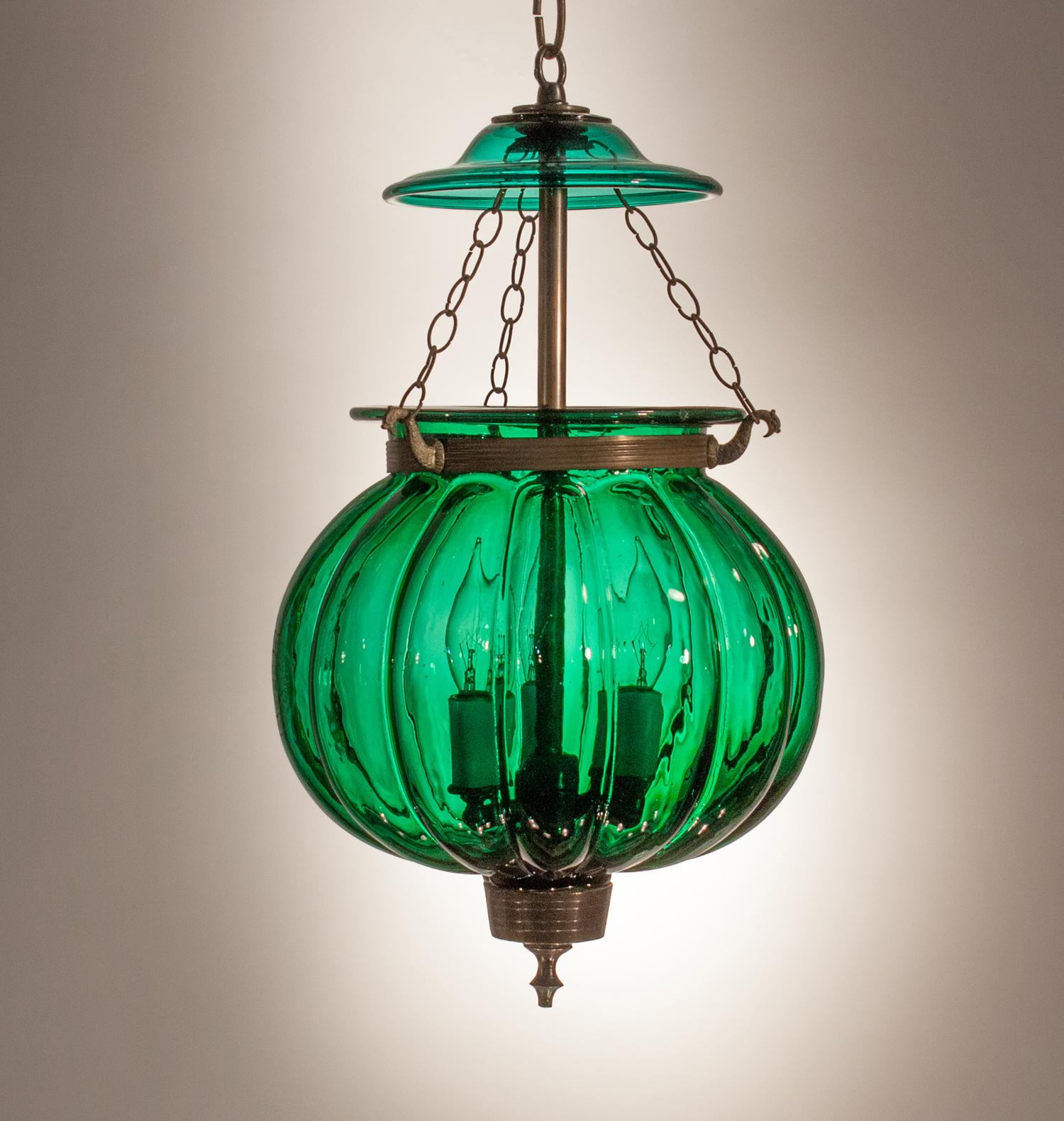 An emerald gem in our bell jar collection, this circa 1890 pumpkin- or melon-shaped lantern is in excellent condition for its age, with desirable air bubbles and swirls in the hand blown glass. The bell jar has its original brass finial and chains.