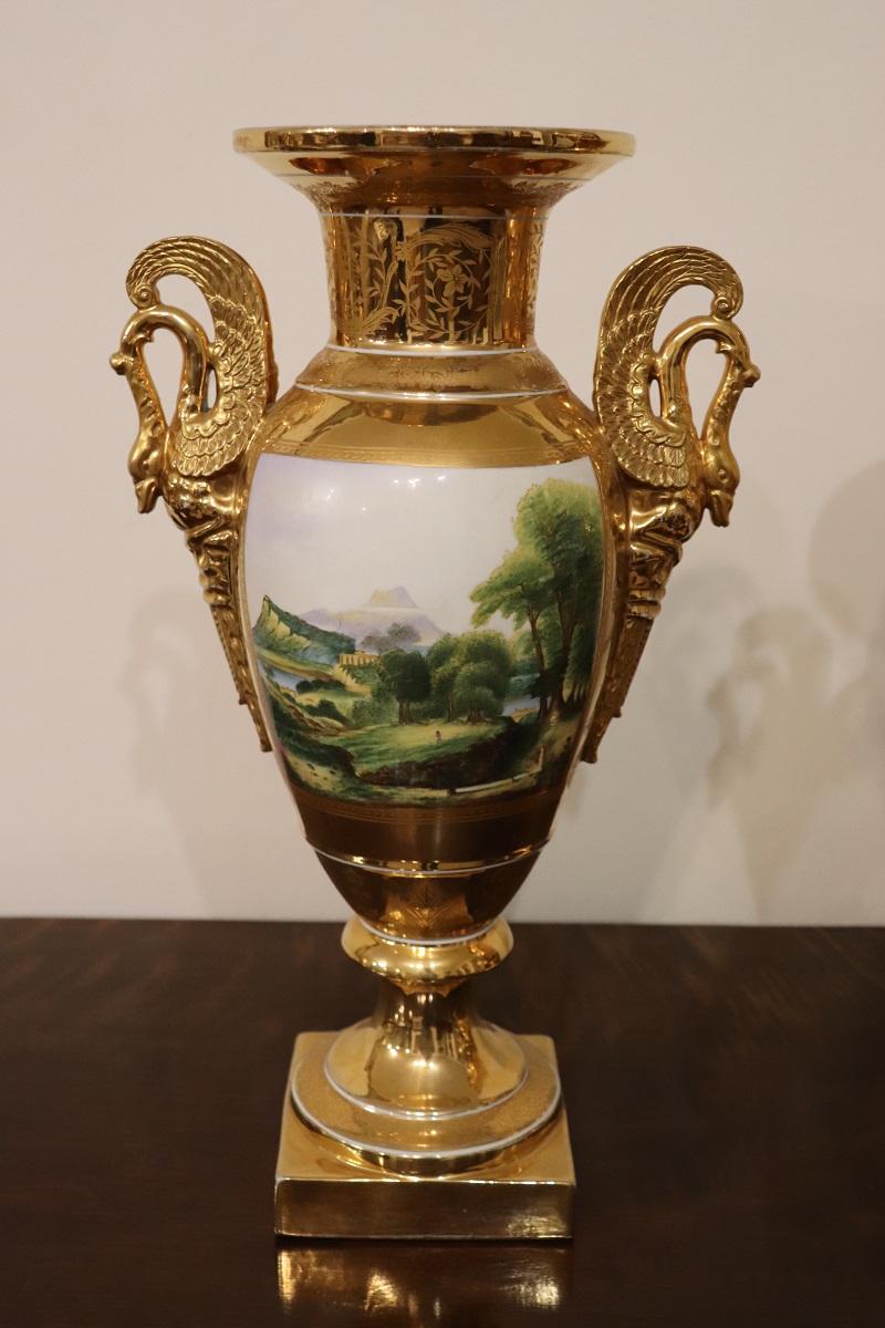 Nous présentons cette fantastique paire de vases amphora en porcelaine, période Empire, première moitié du 19e siècle. Les deux vases sont caractérisés par une riche décoration. L'attention est certainement captée par la fantastique dorure en