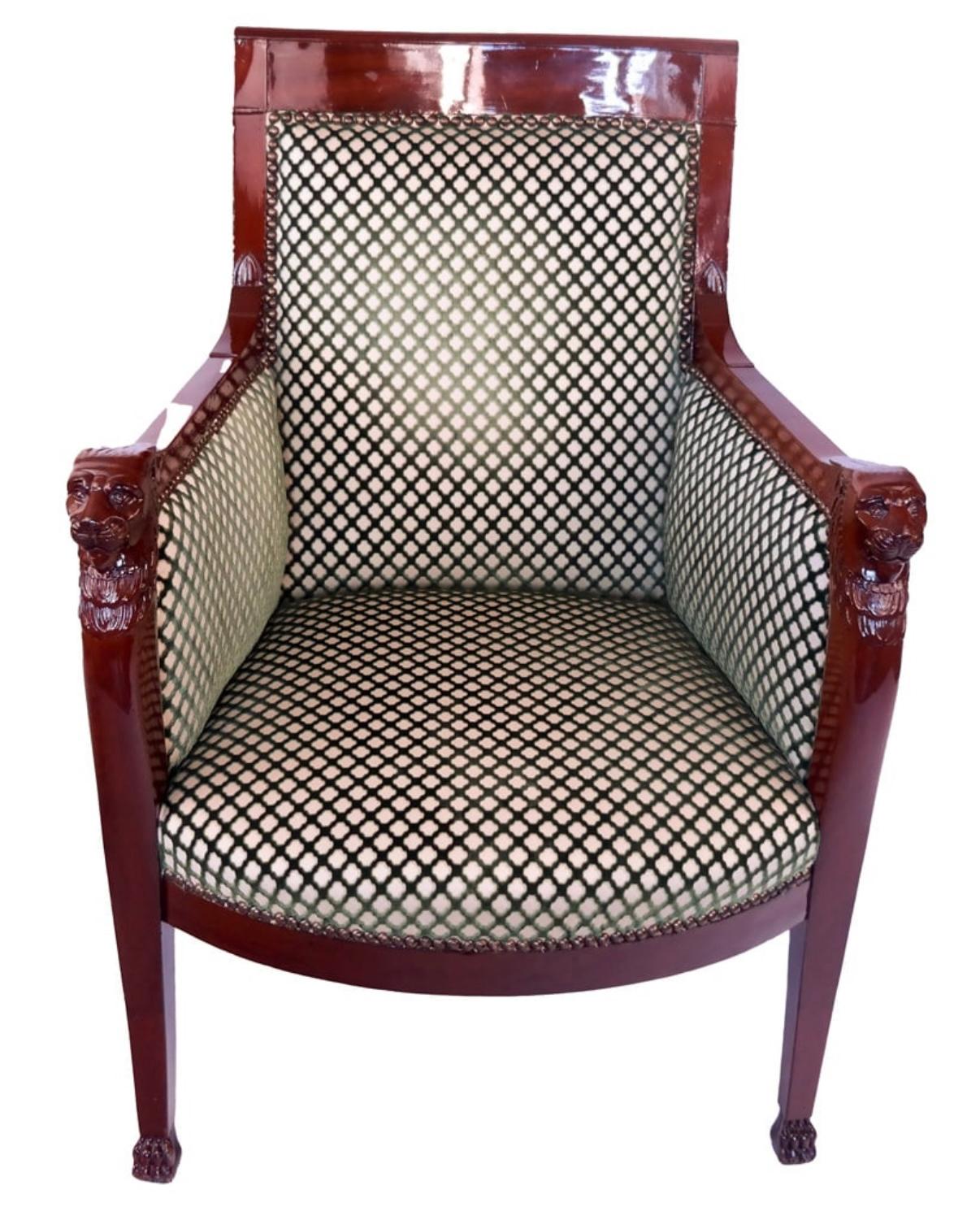 This striking armchair is a fine example of 19th-century Empire furniture, marrying neoclassical authority with updated decorative luxury. The frame, likely crafted from mahogany or another dense tropical hardwood, is finished in a deep, lustrous