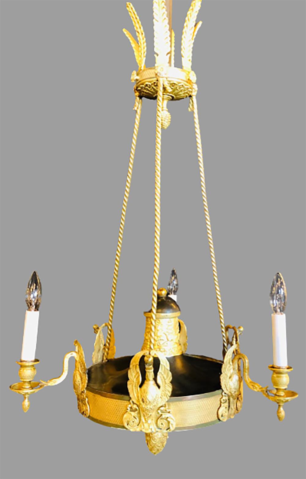 19th century empire chandelier with full figure swan arms. This simply stunning doré bronze chandelier has full bodied swans holding three candlestick lights. The whole with a matching canopy.