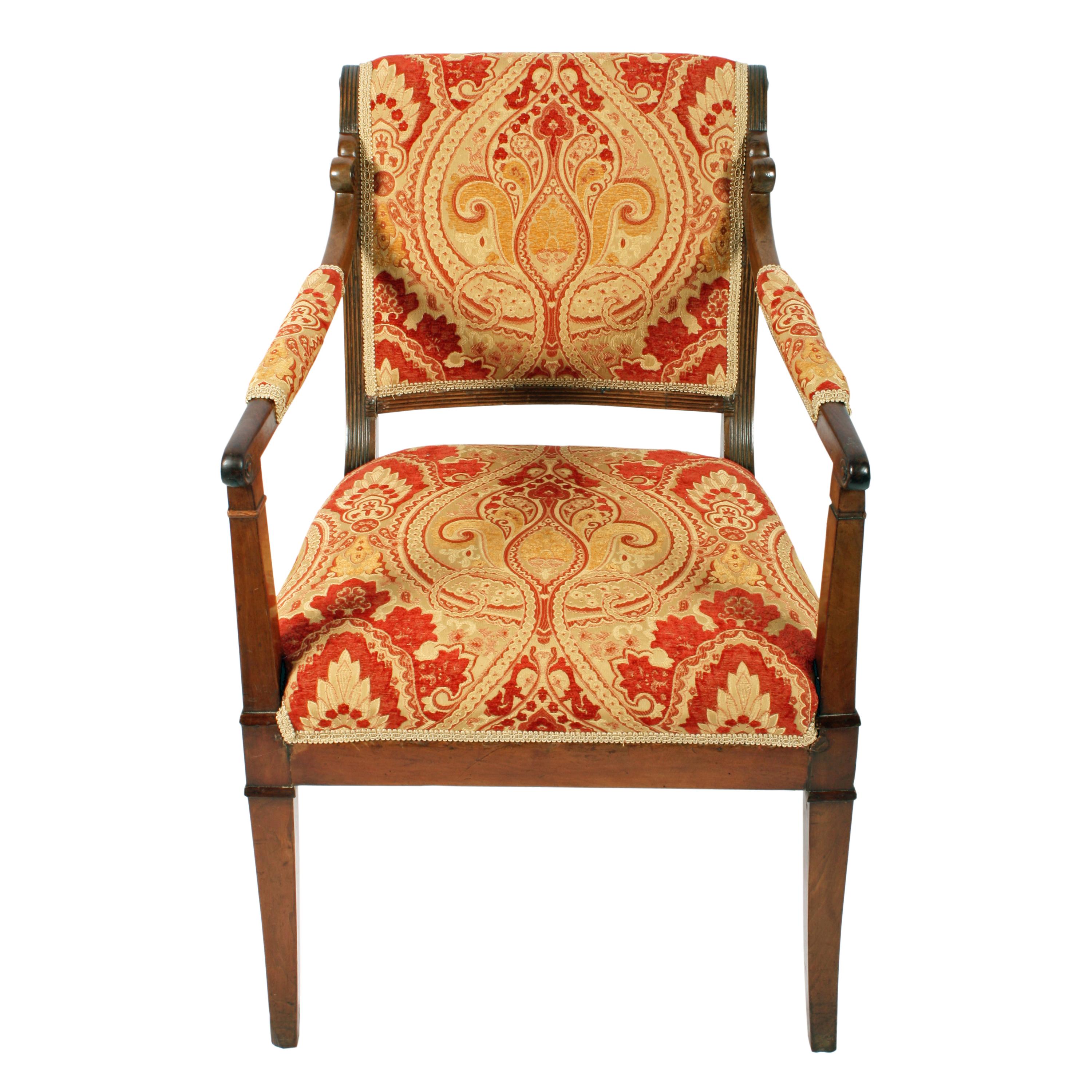 Early 19th century mahogany framed Empire design elbow chair.

The chair has square sabre legs front and back with square tapering supports for the arms.

The chair has a rollover top to the back with a reeded frame either side of the padded