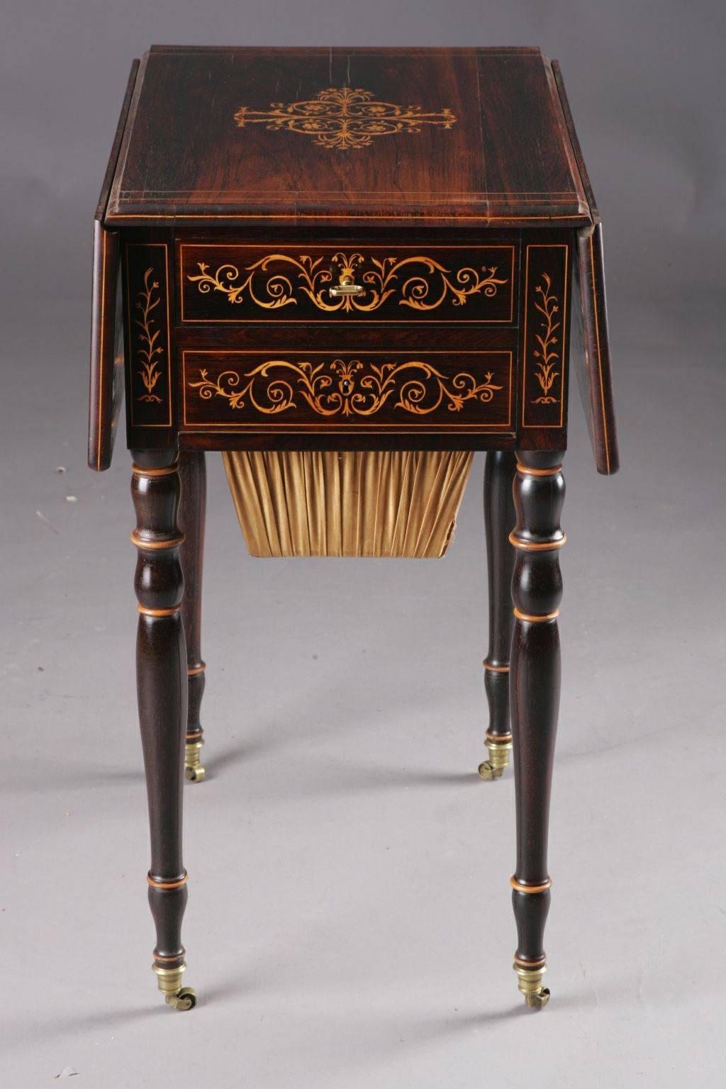Exceptional English sewing table, circa 1825. Mahogony on solid hardwood. Two-handed frame box, including woolen containers on balustrade-shaped feet in bronze caps ending in rolls. Placed on all sides with neoclassical ornaments from maple.
