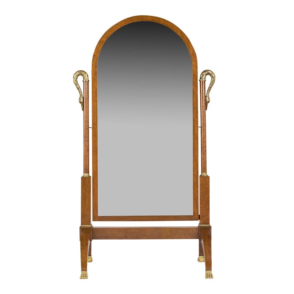 This French early 19th-century empire standing mirror is a great condition the mirror has been newly refurbished. It features a solid wood frame covered with birch eye veneers finished in light walnut color, an arched-top frame, two hand-carved