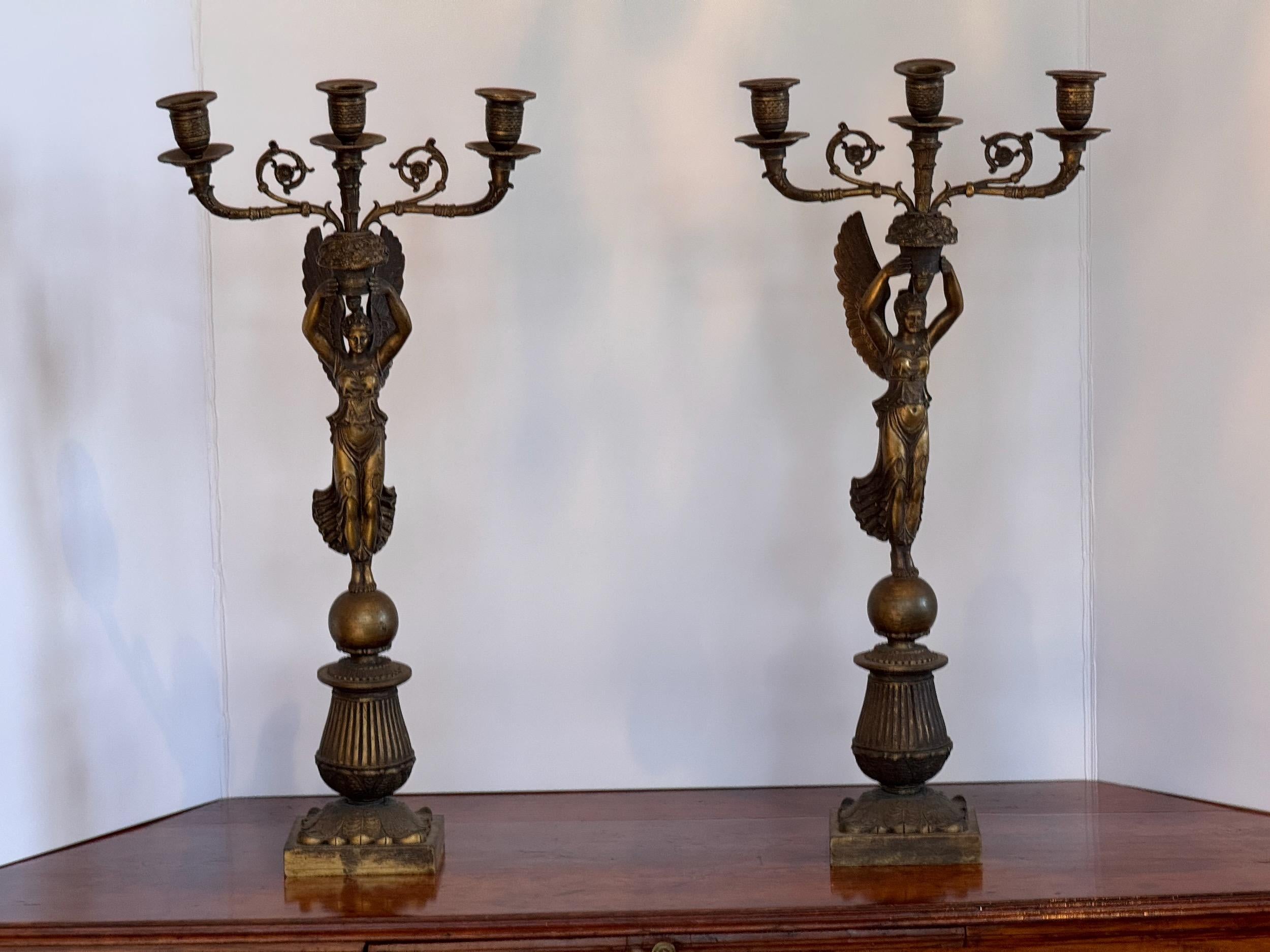 Coppia di portacandele in stile neoclassico. Ognuna contiene tre candele.