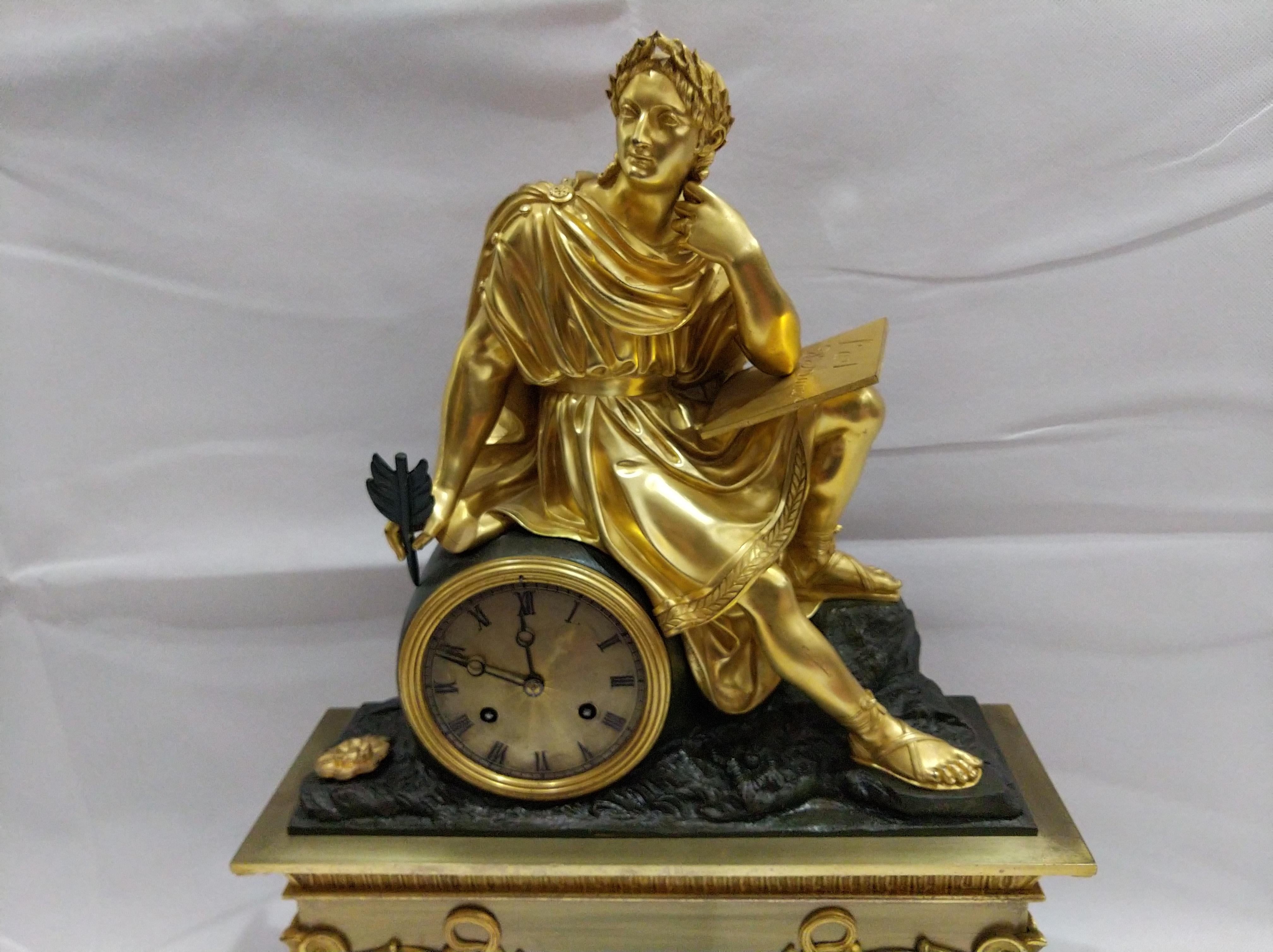 Empire gilded pendulum clock with Ovid (Roman poet who lived during the reign of Augustus) sitting on the dial writing 